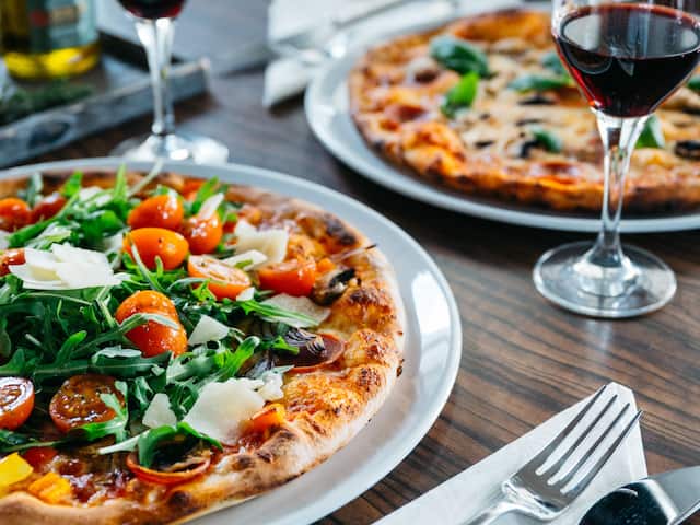 A delicious-looking pizza from a restaurant in a hotel at the Nürburgring with tomatoes, arugula, and parmesan