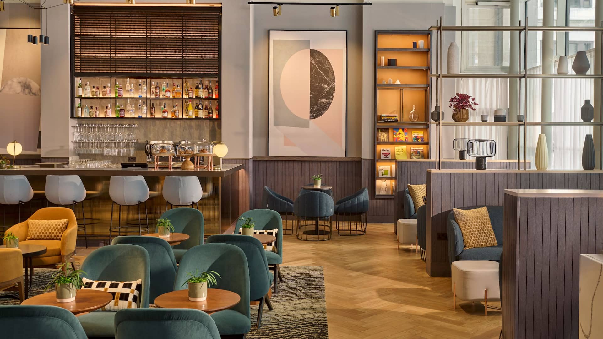 Regency Club area of Hyatt Blackfriars with blue sofas, quiet seating area and a bar serving cocktails, daily refreshment and breakfast.