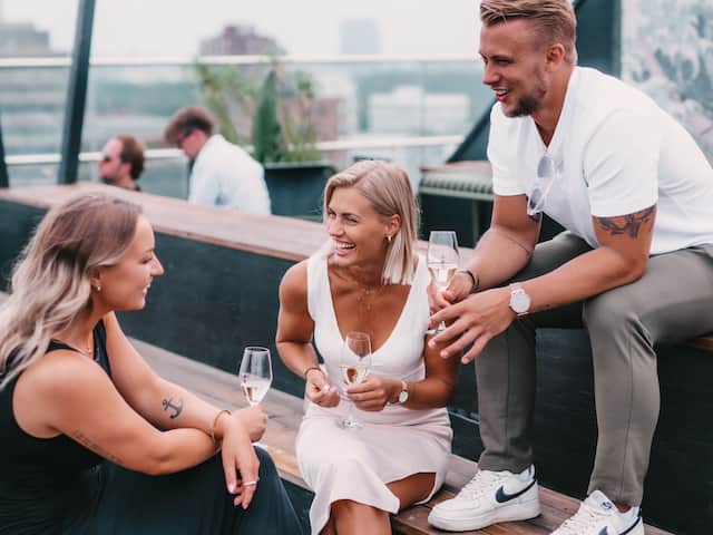 Guests having a good time with a glass of champagne at the Roof top at Story Hotel Studio Malmö