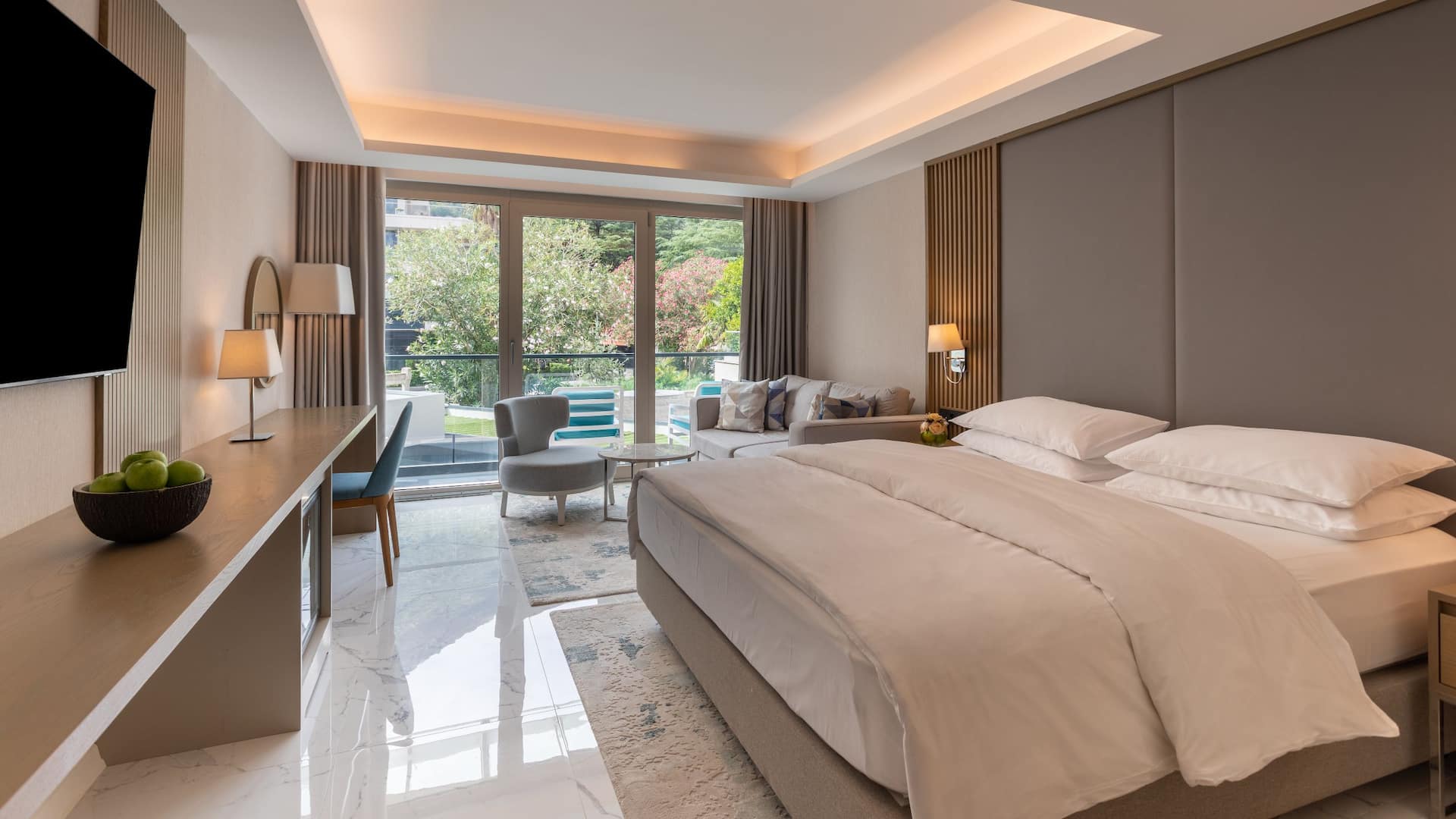 1 de 5 Spacious hotel room at Hyatt Regency Kotor Bay with a king bed, elegant decor, and a private balcony overlooking lush greenery.