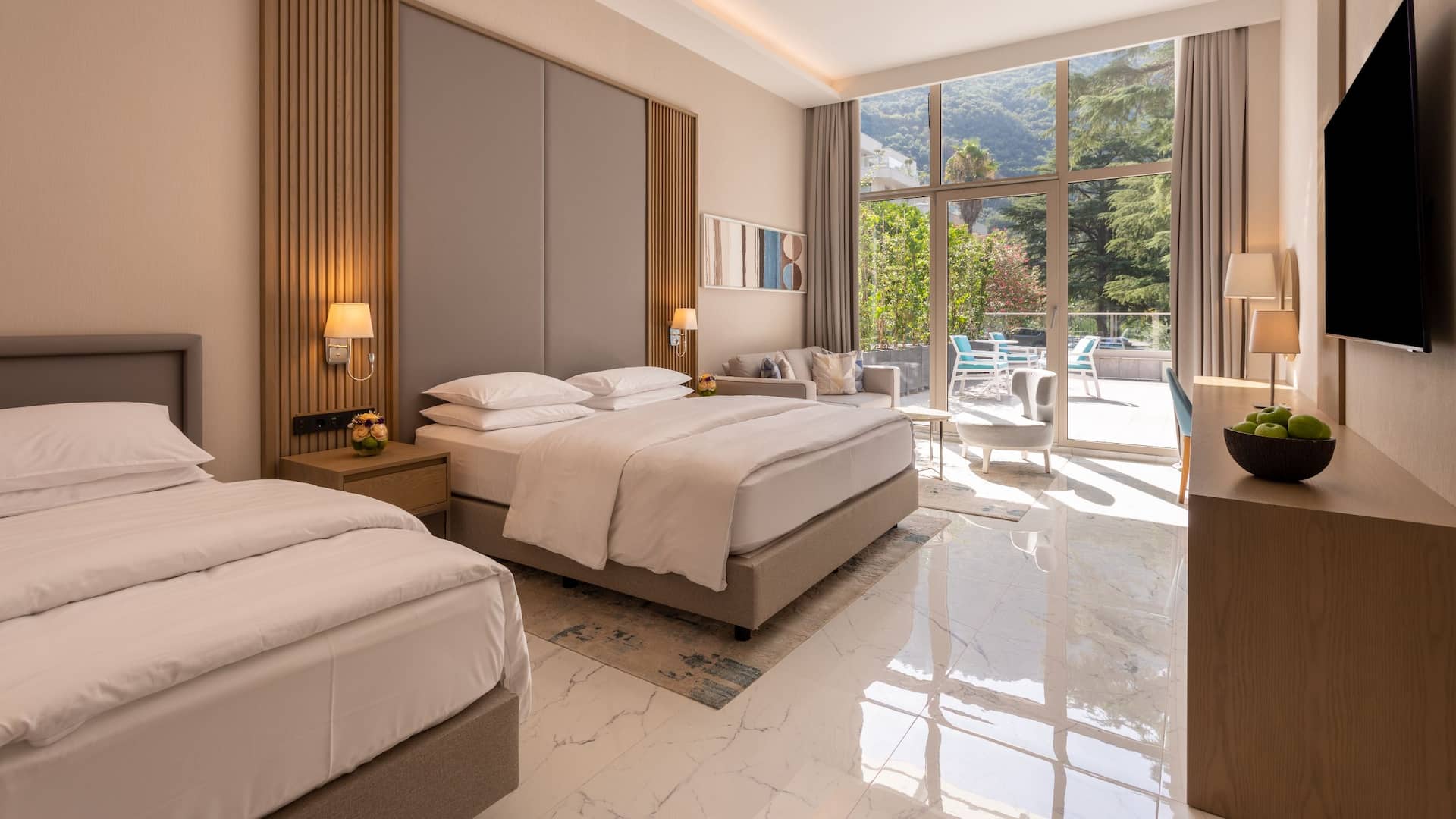 1 de 5 Premium hotel room at Hyatt Regency Kotor Bay with a king bed, twin bed, and a spacious terrace surrounded by greenery.