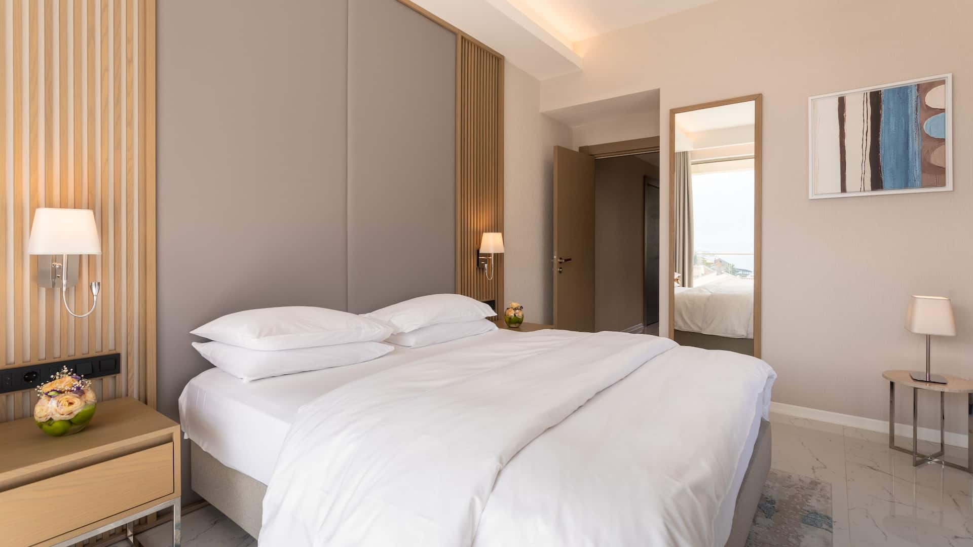 Luxury suite bedroom at Hyatt Regency Kotor Bay Resort, Montenegro, offering a serene ambiance and panoramic views of the Adriatic Sea from the comfort of the bed.