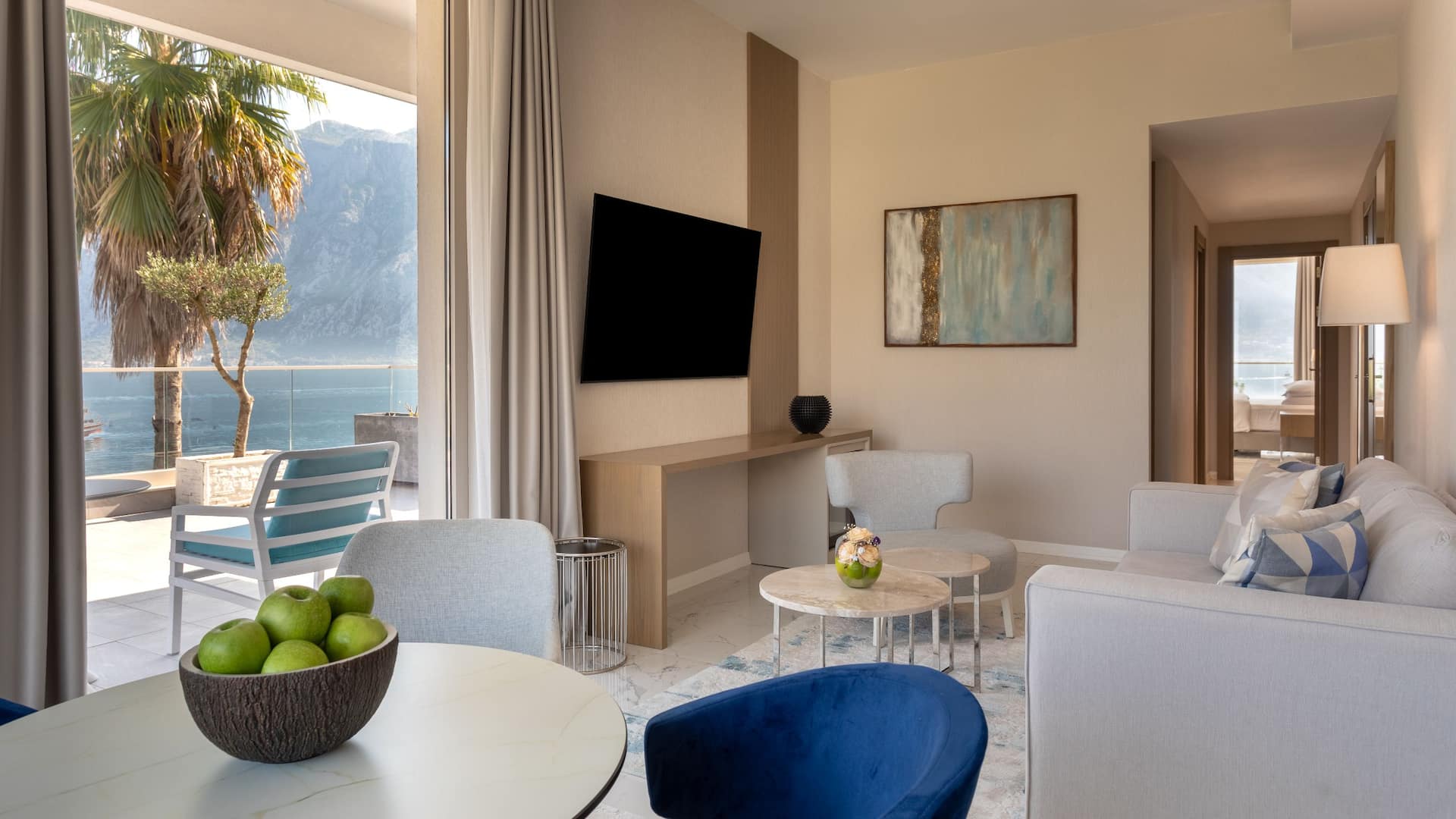 Elegant living room in a luxury suite at Hyatt Regency Kotor Bay Resort, Montenegro, featuring contemporary decor and expansive sea views through large windows.