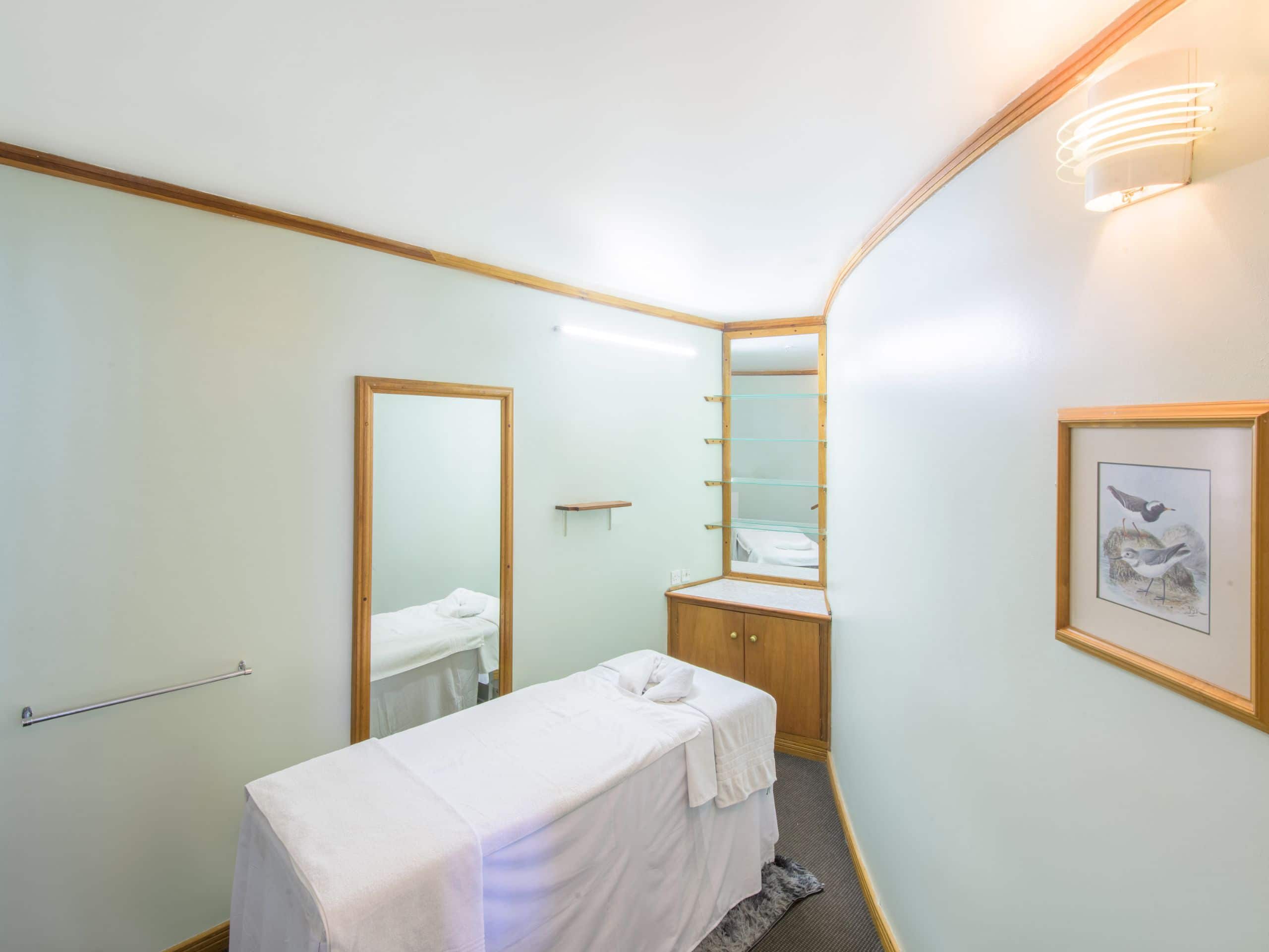 Spa Treatment room in Harare hotel featuring a massage bed and mirror