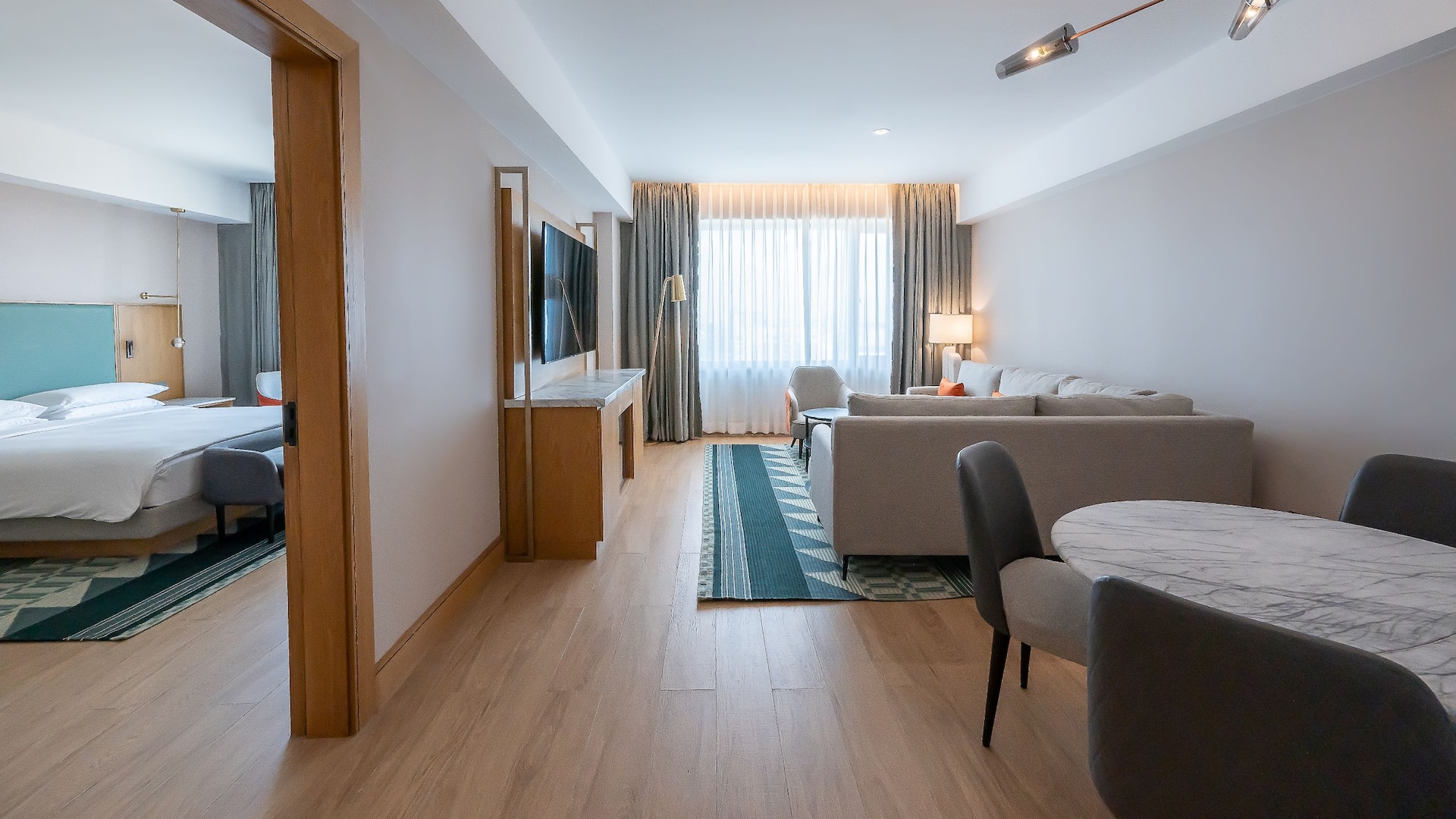 Hotel Suite with large bed, city views, separate sitting area and tribal print inspired décor.