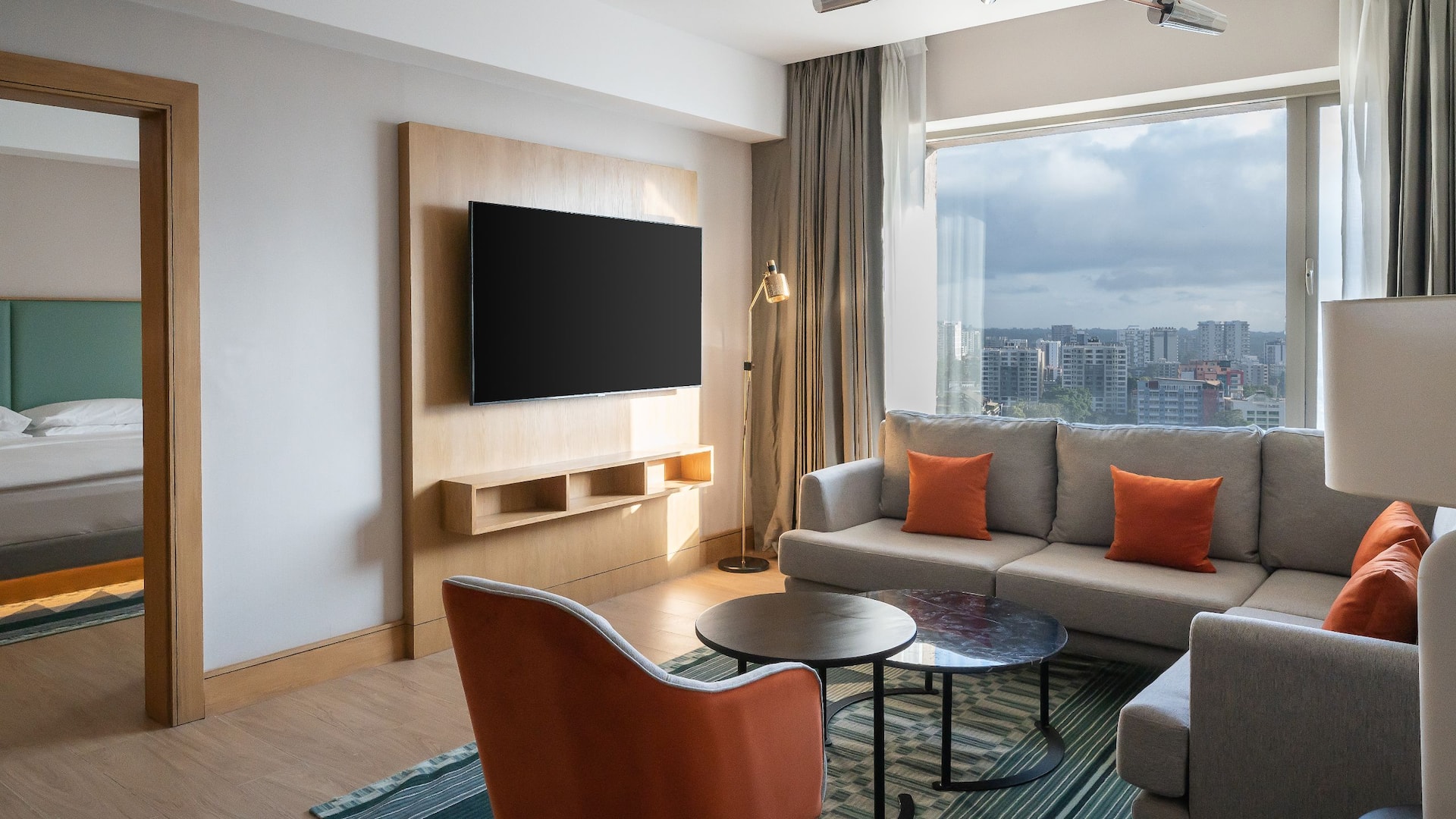 1/5 Elegant one-bedroom apartment in the heart of Westlands featuring a modern living room area with a panoramic view of the city and a separate bedroom area with a king bed.