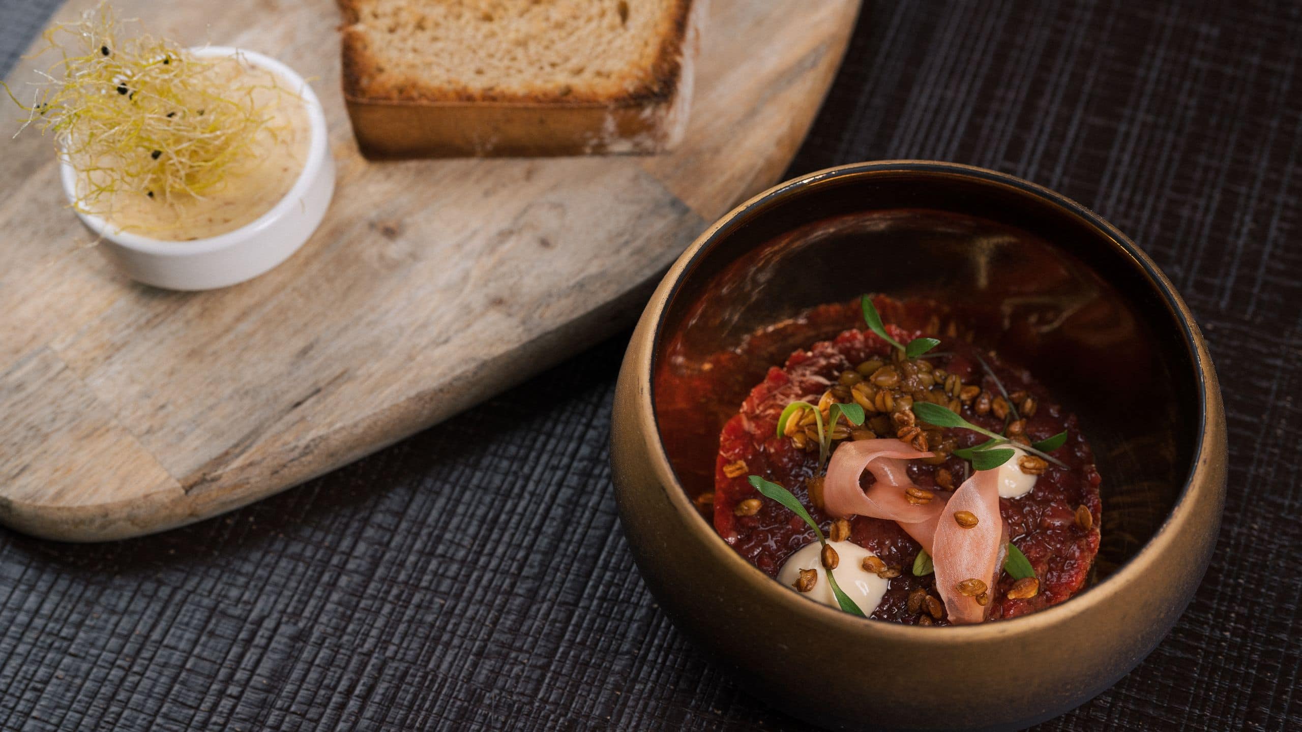  beautifully plated beef tartare served with butter and freshly baked potato bread