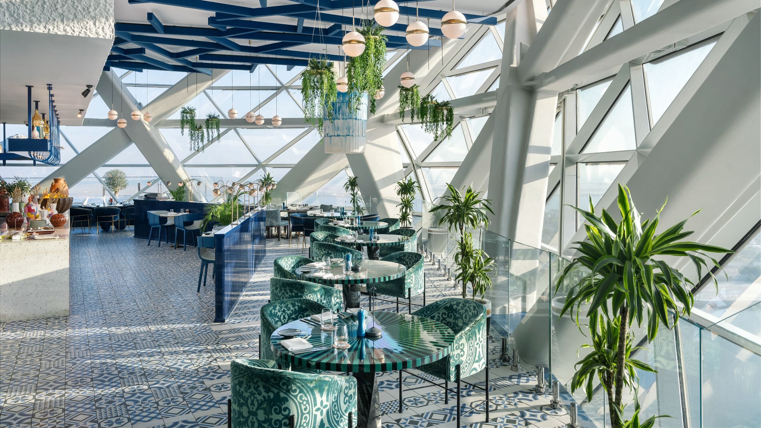 Elegant and sophisticated Cyan Brasserie restaurant ambience with curved floor-to-ceiling window view at Andaz Capital Gate Abu Dhabi Restaurant