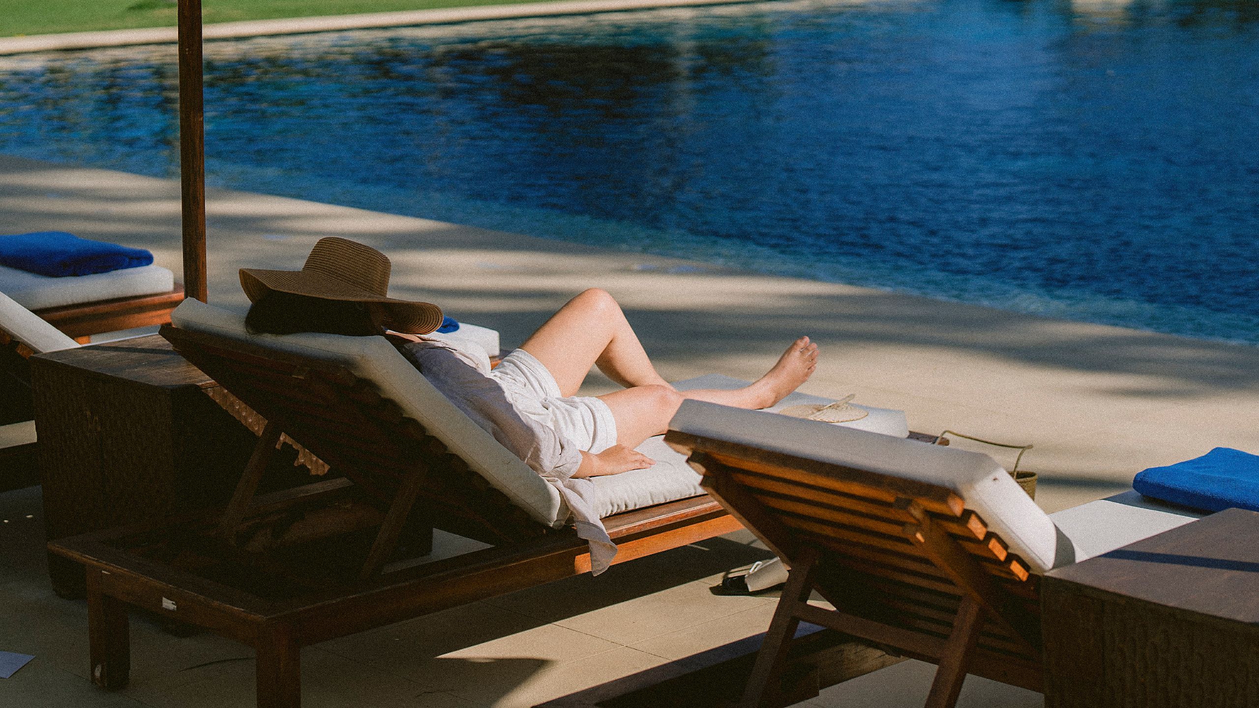 Alila Manggis Woman By The Pool Sitting With Hat
