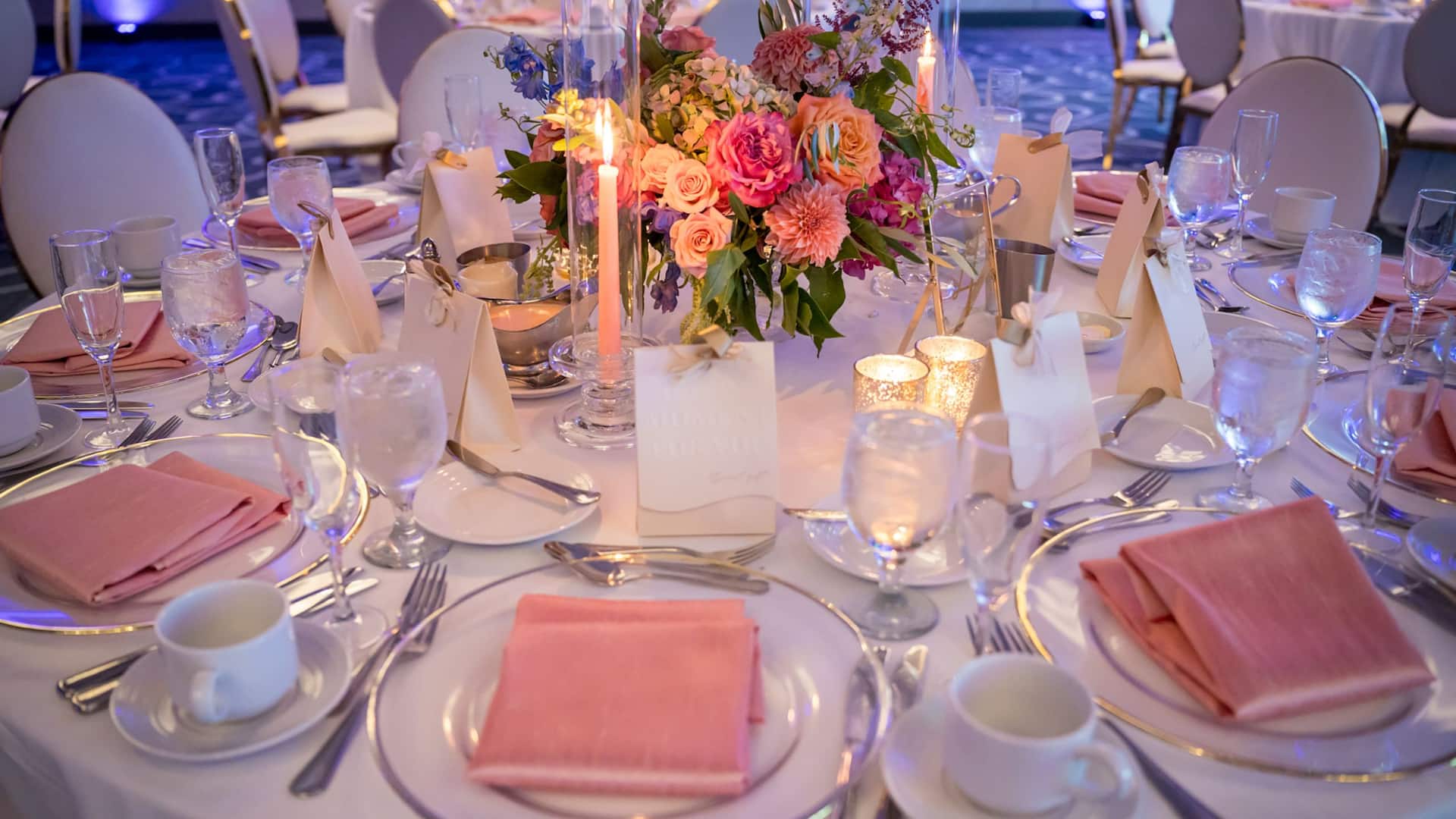 Round wedding table set up with pink candles and flower decoration