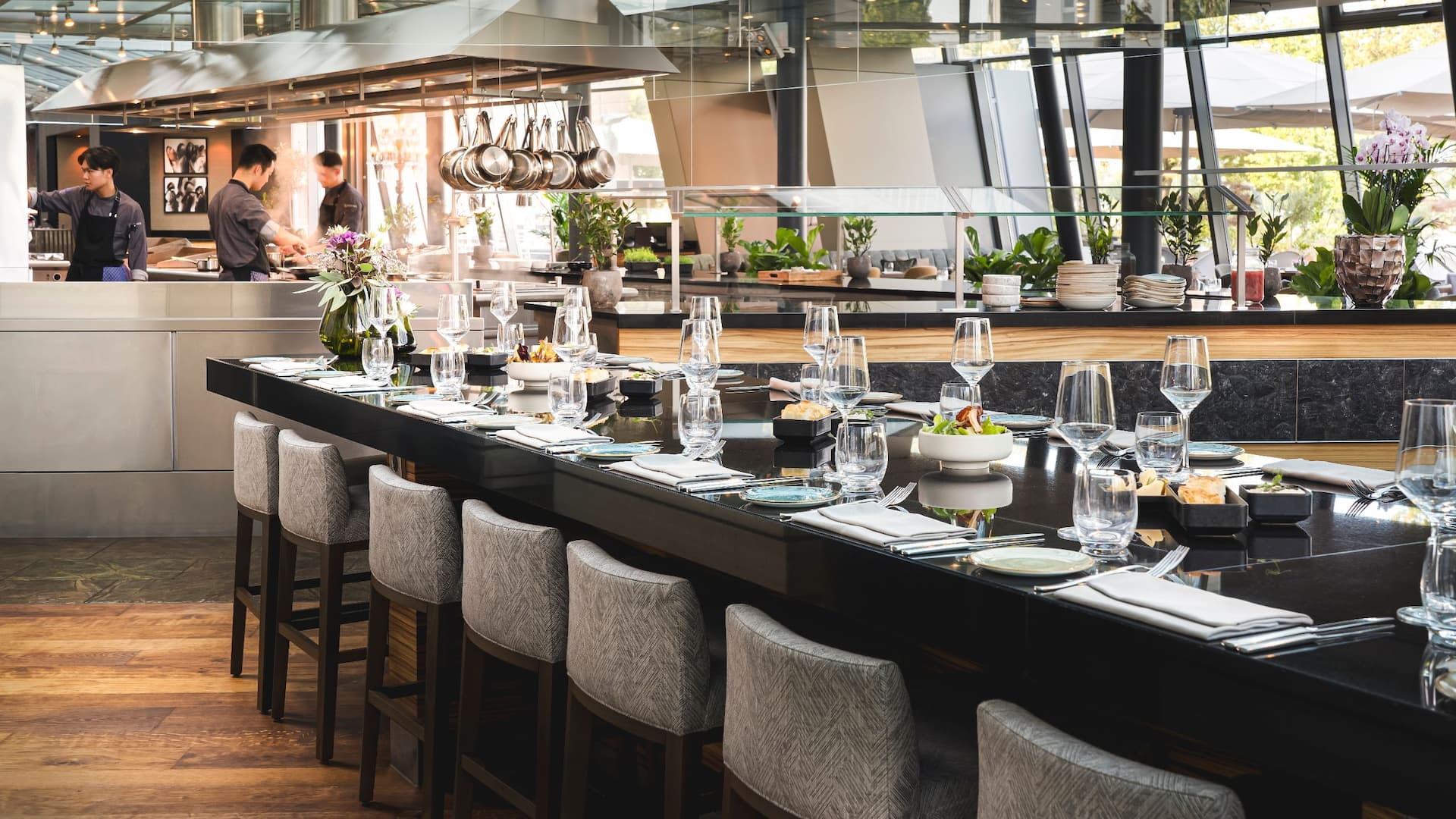 Large Chefs table with show kitchen in the background at Bellpepper Restaurant of Hyatt Regency Mainz