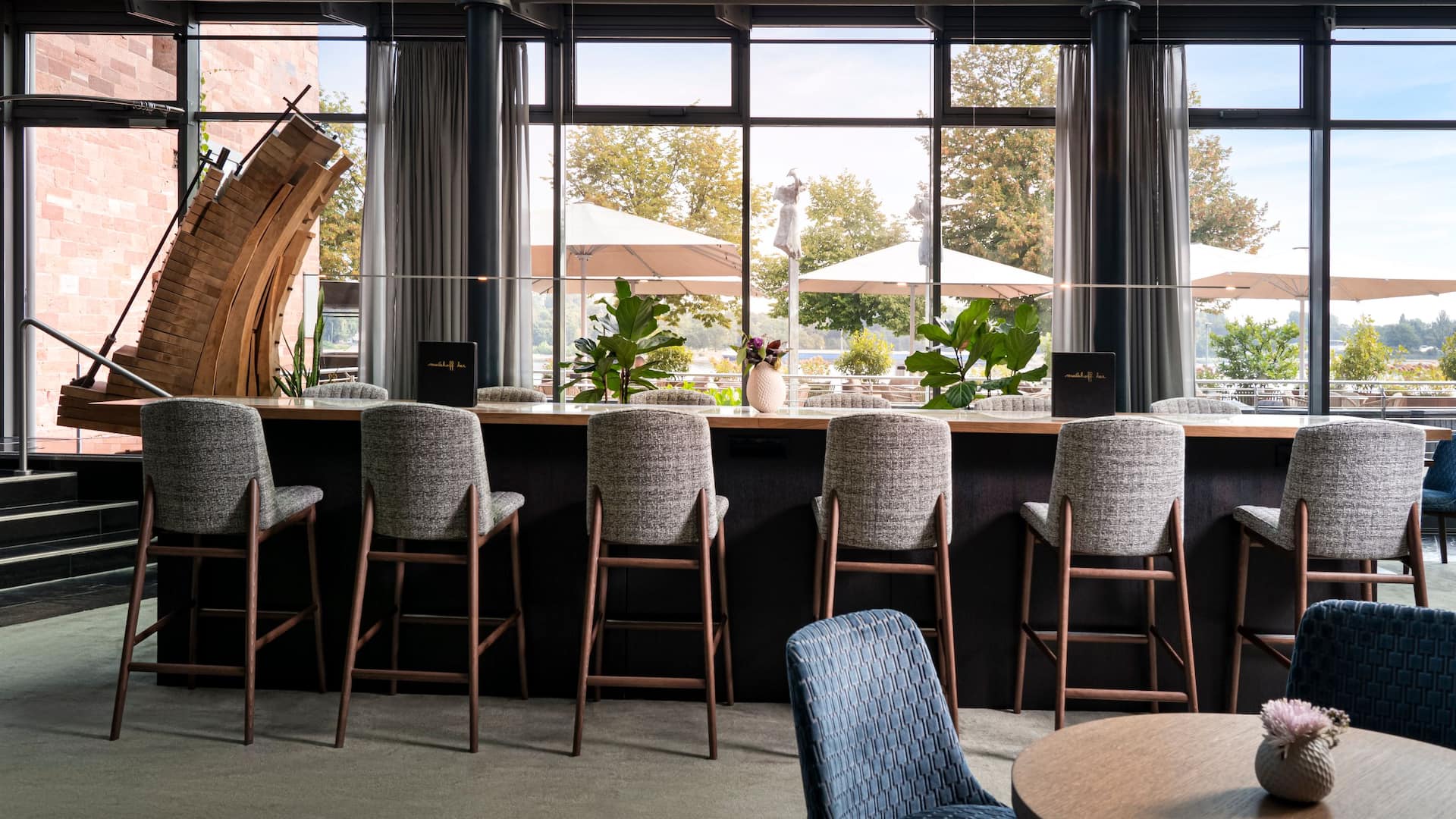 Community table at M Lounge in the modern and stylish ambiance of Hyatt Regency Mainz with vies of the restaurant terrace