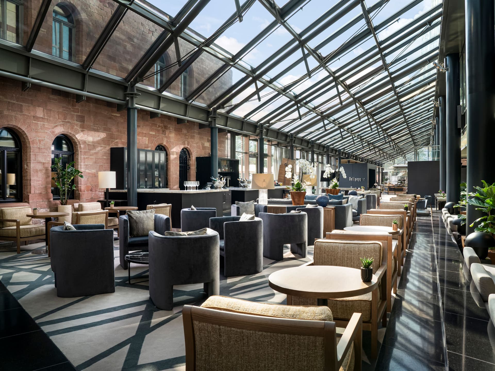 Inviting seating area of the M Lounge with glass roof and between historic Fort Malakoff and lobby of Hyatt Regency Mainz