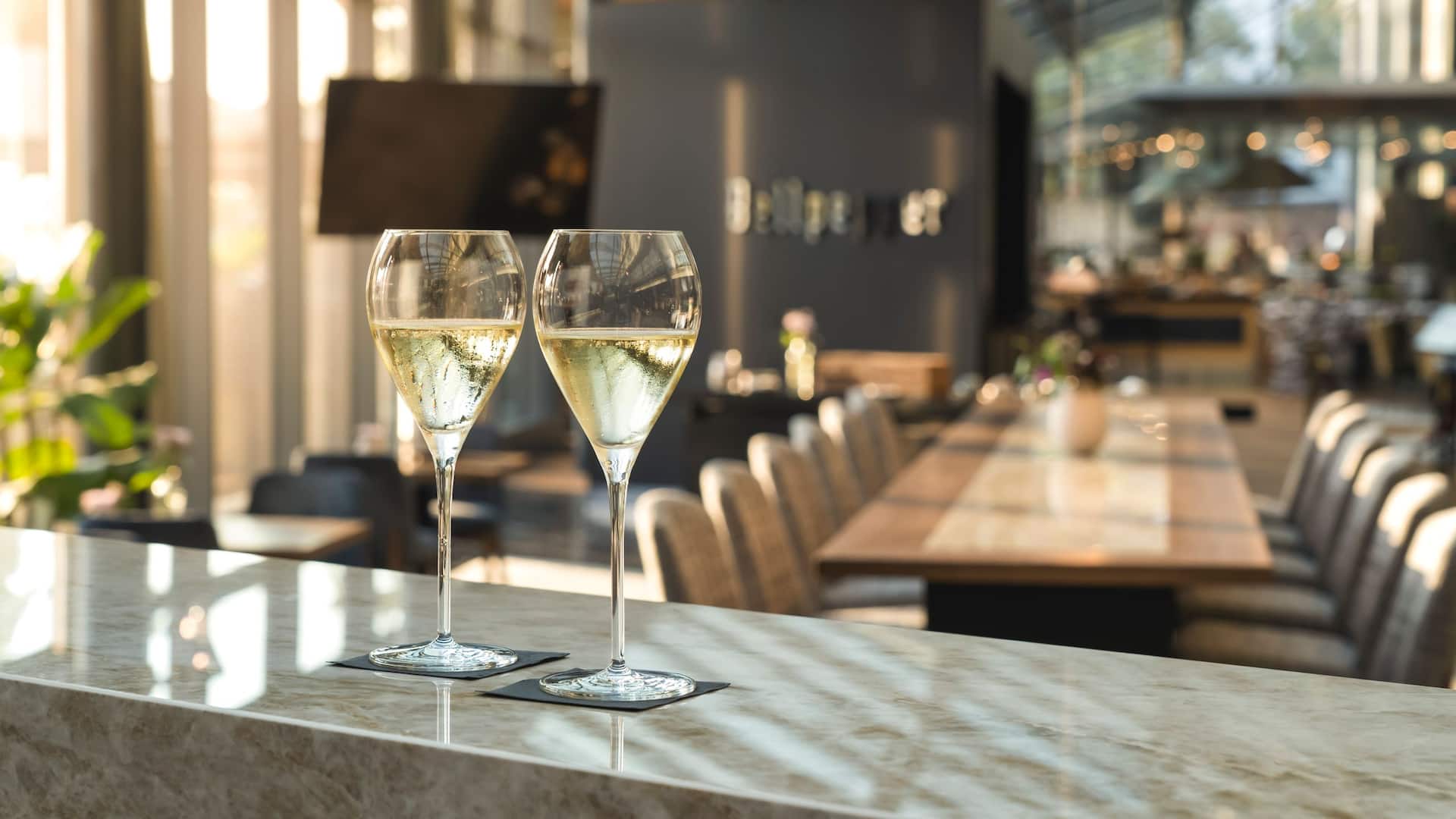 Community table at M Lounge with two glasses of Champagne in the modern and stylish ambiance of Hyatt Regency Mainz