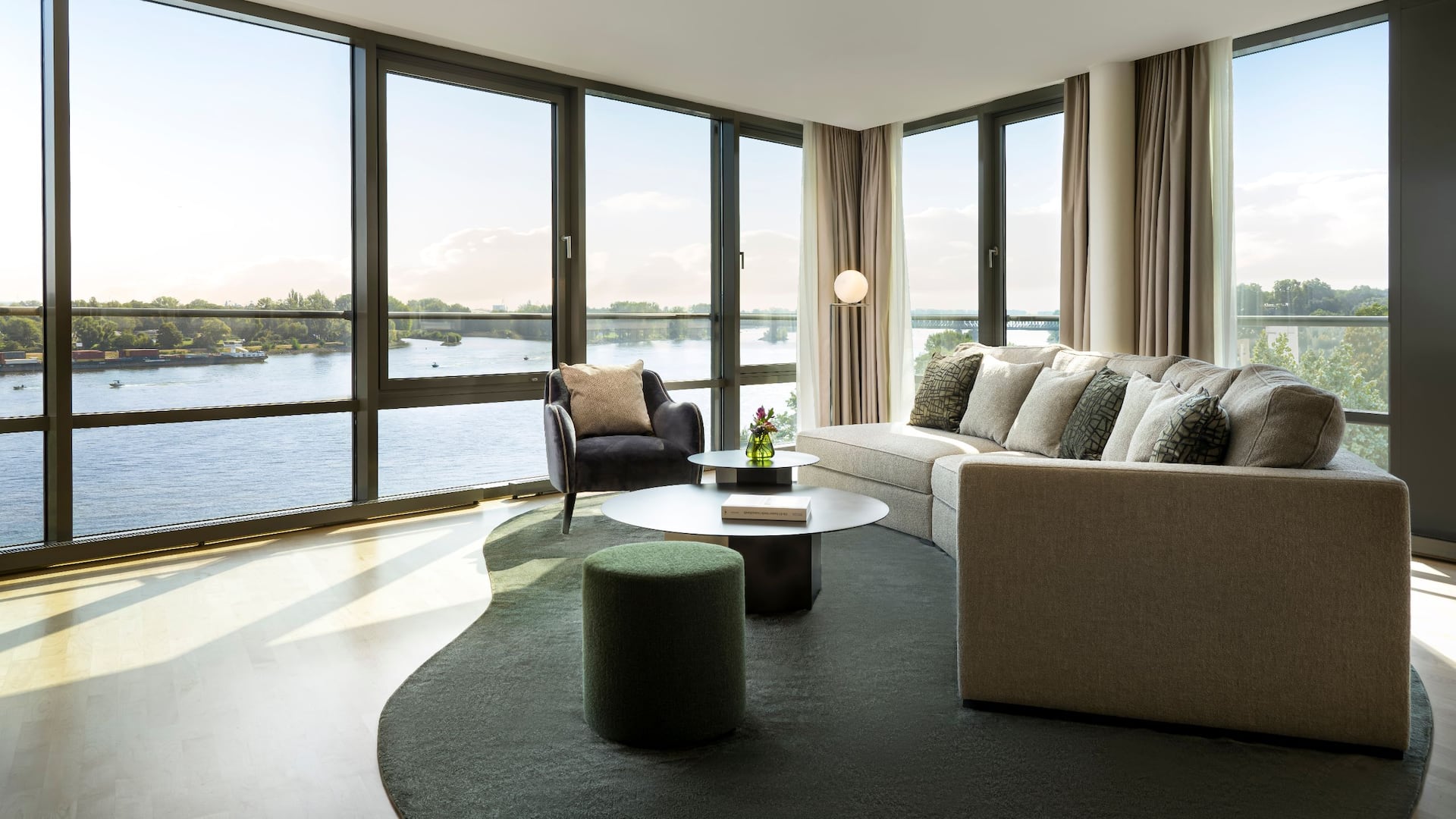 Spacious living room with panoramic windows and elegant furniture overlooking the Rhine at Hyatt Regency Mainz