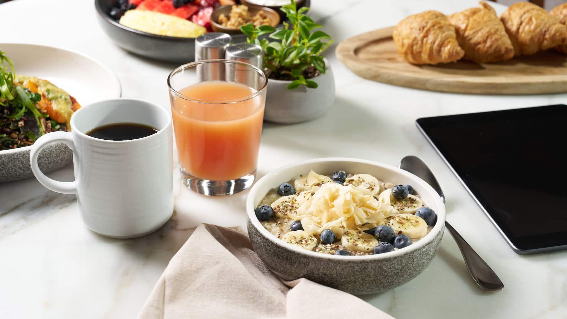 1 of 1 Hyatt Regency HR_P0508 Breakfast Spread With Oatmeal And Laptop