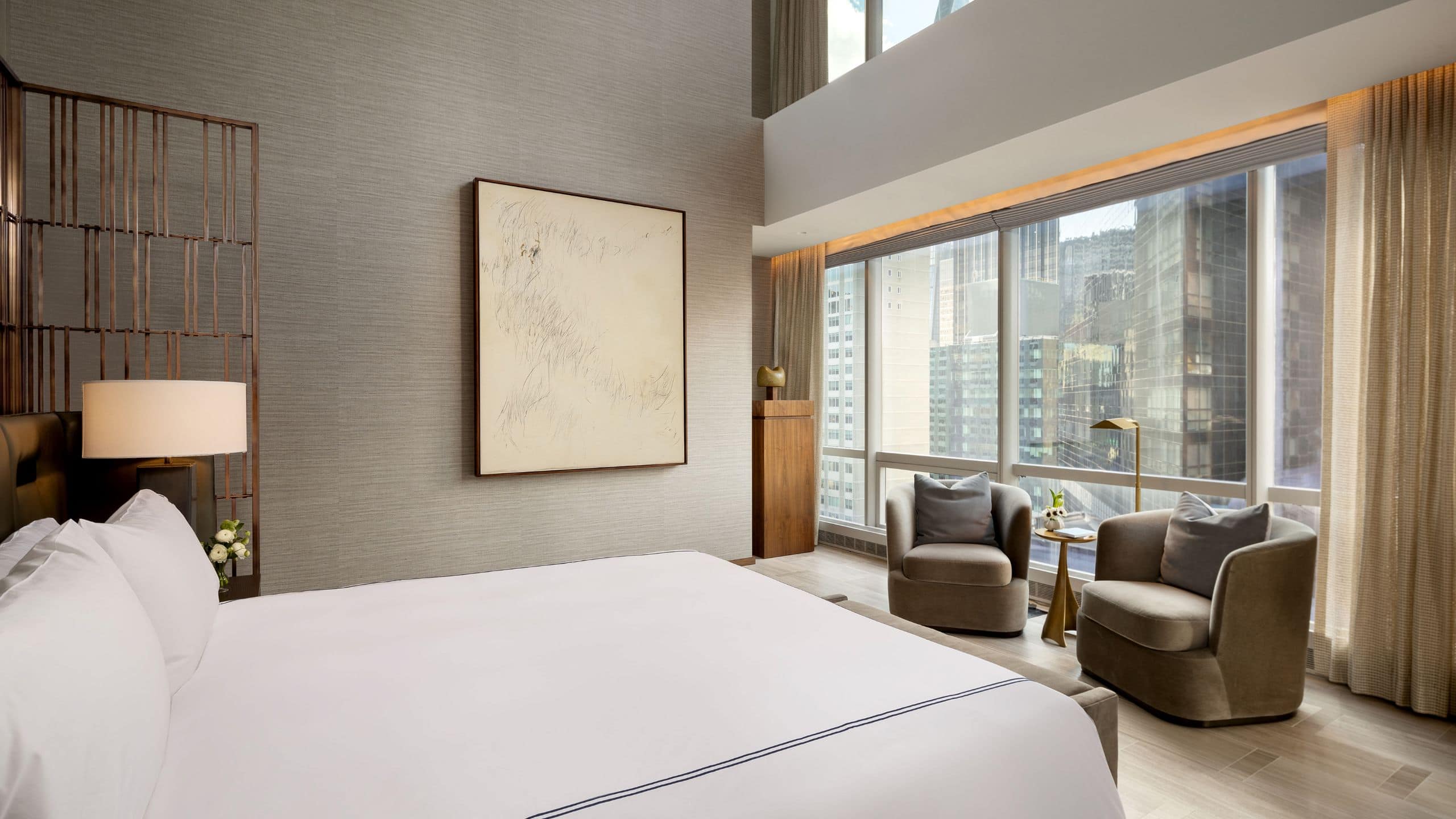 Manhattan Suite bedroom with large king sized bed and seating area with city views