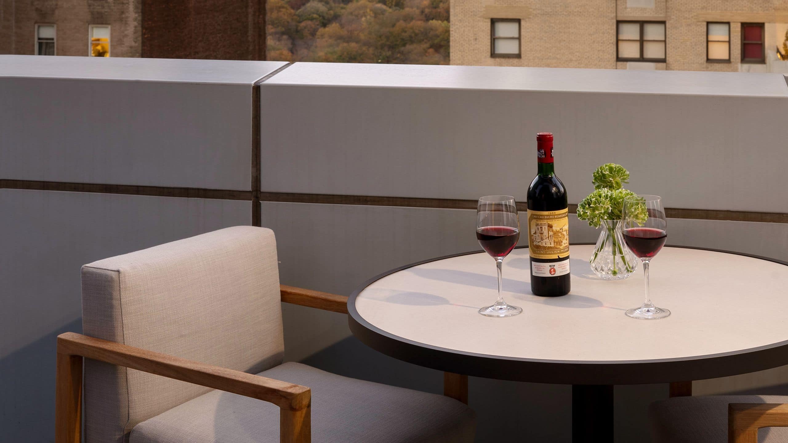 6 из 7 Suite balcony with two chairs, a table, and bottle of wine with partial views of New York city and Central Park