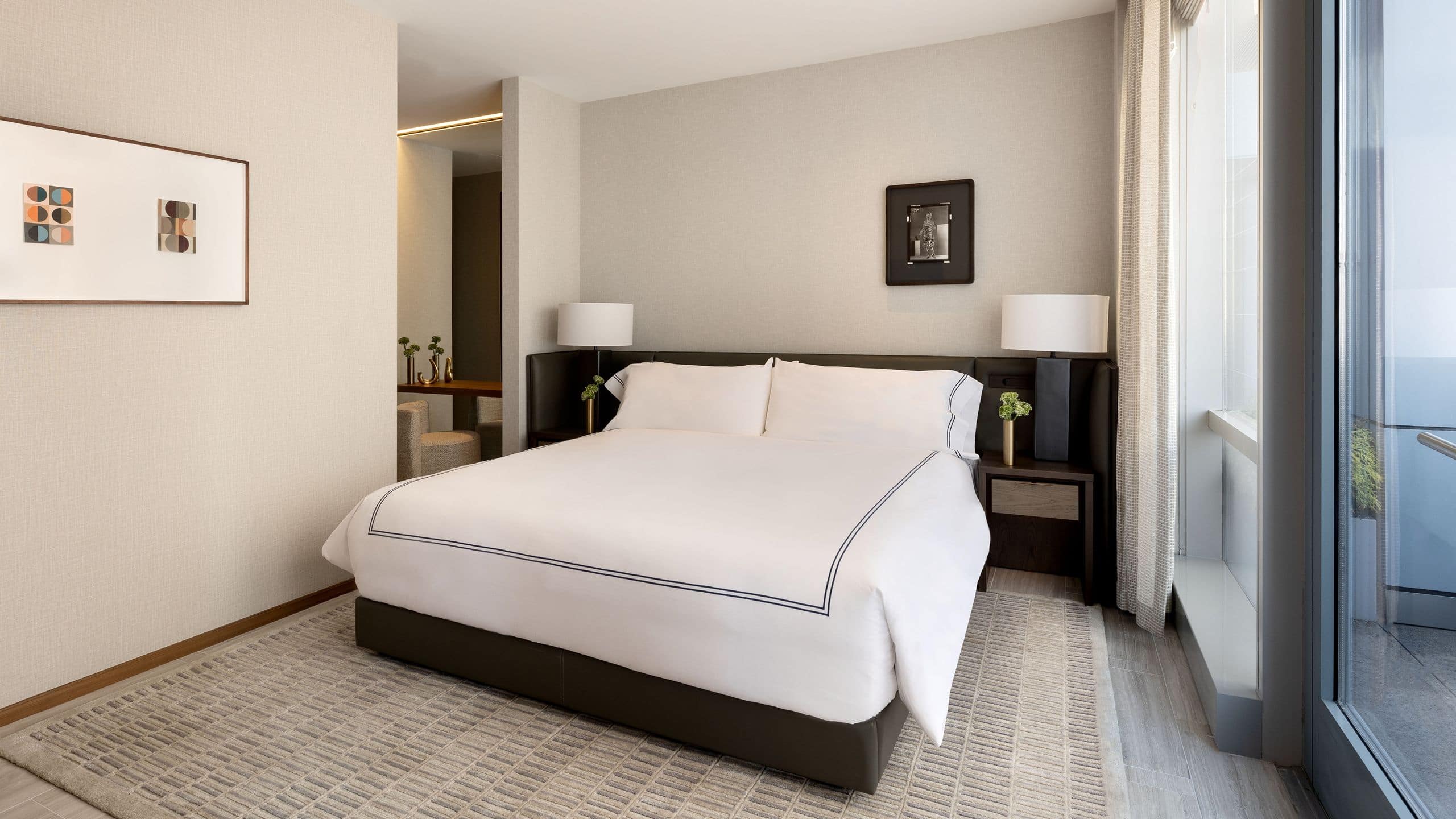 4 из 7 Large airy suite bedroom with a large king bed, two bedside tables and sliding glass doors onto a balcony