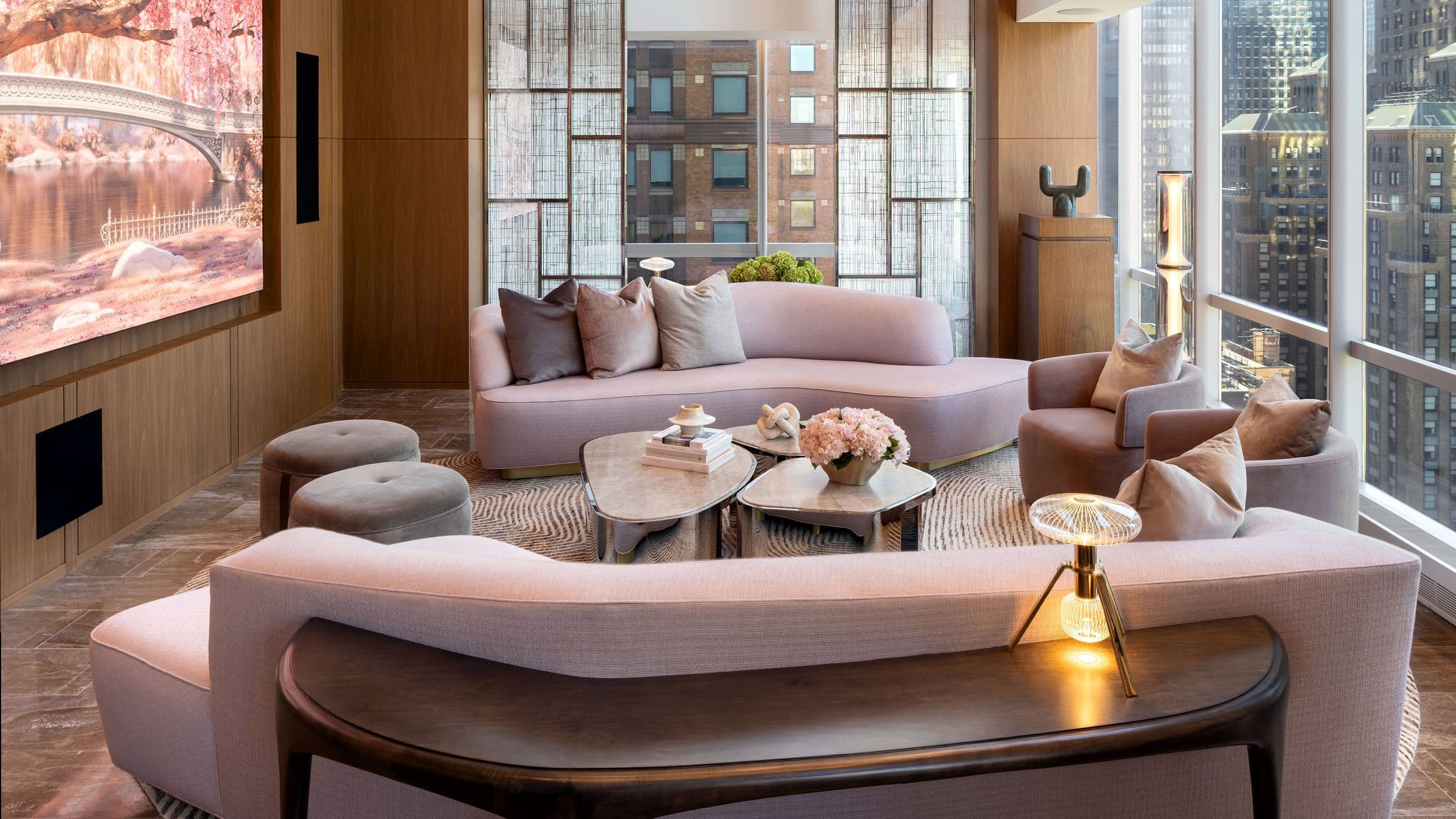 Two couch seating area with large widescreen television featuring custom digital  artwork of cherry blossoms in Central Park