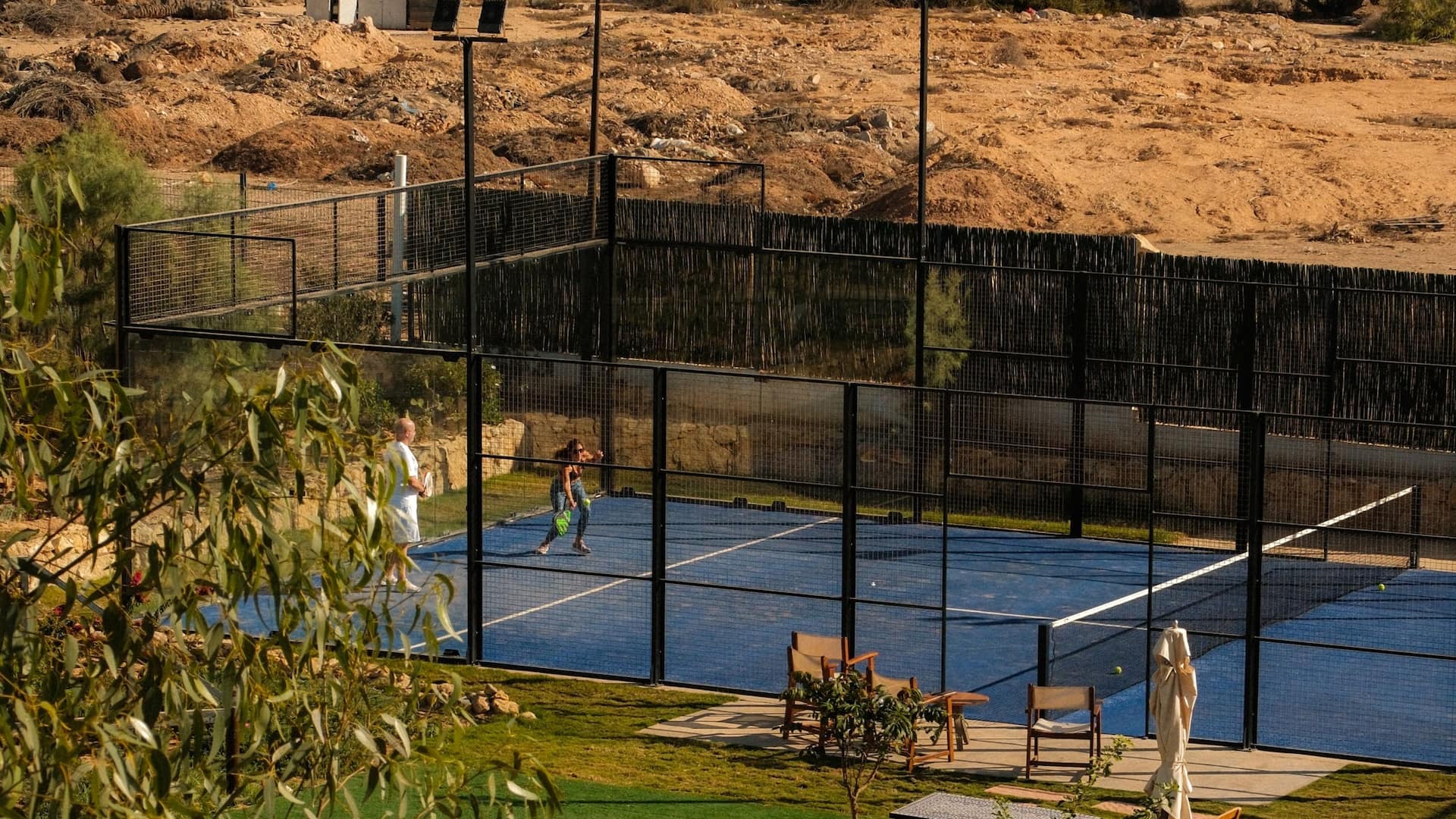 Padel court with players in action, showcasing a lively match and dynamic  gameplay