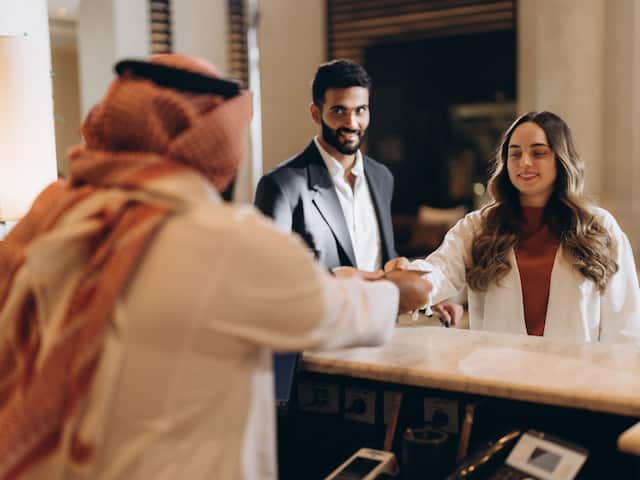 Couple Check In At Reception Desk