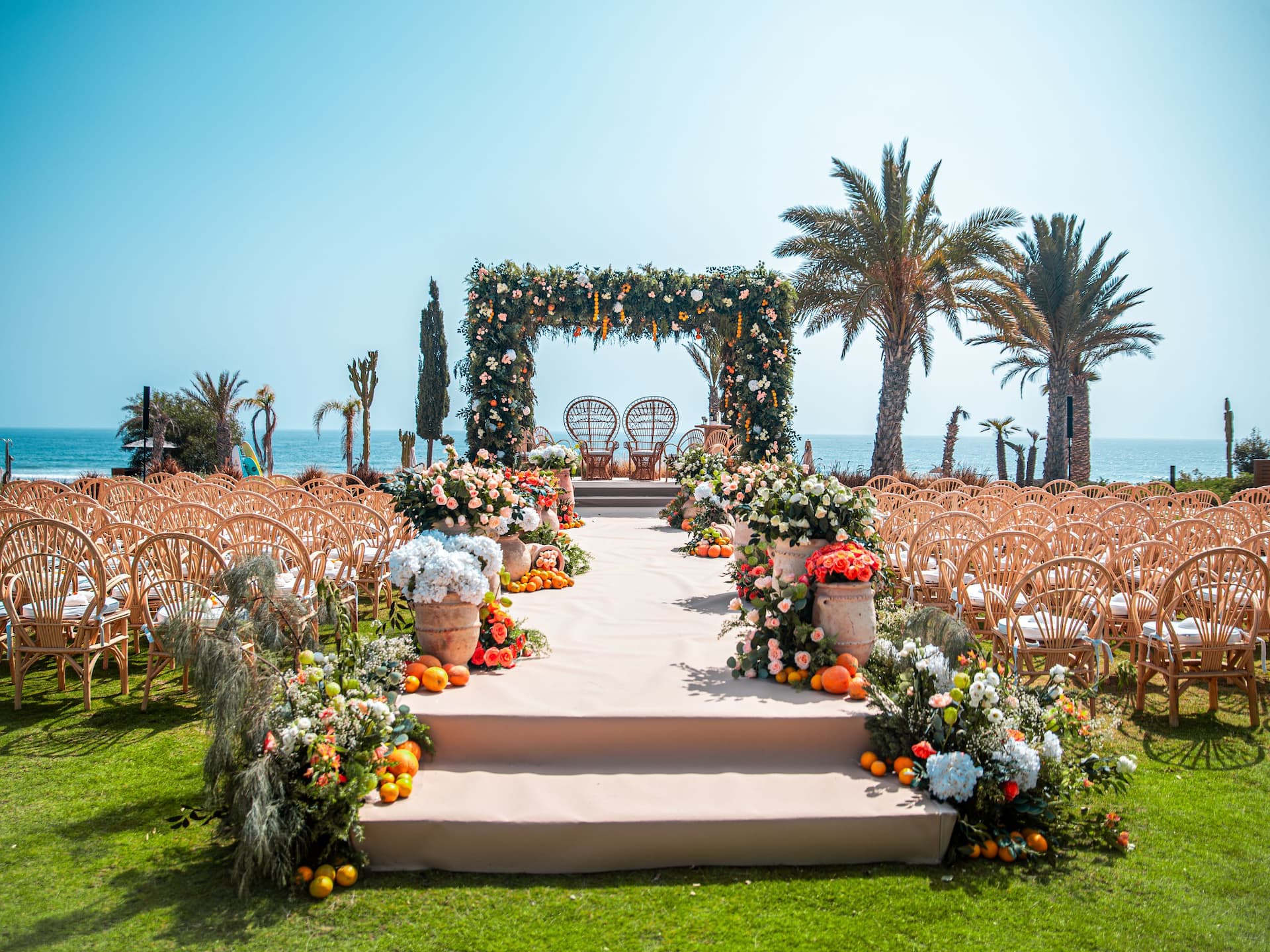 Garden wedding setup by the sea, featuring palm trees for a picturesque and  tropical ambiance
