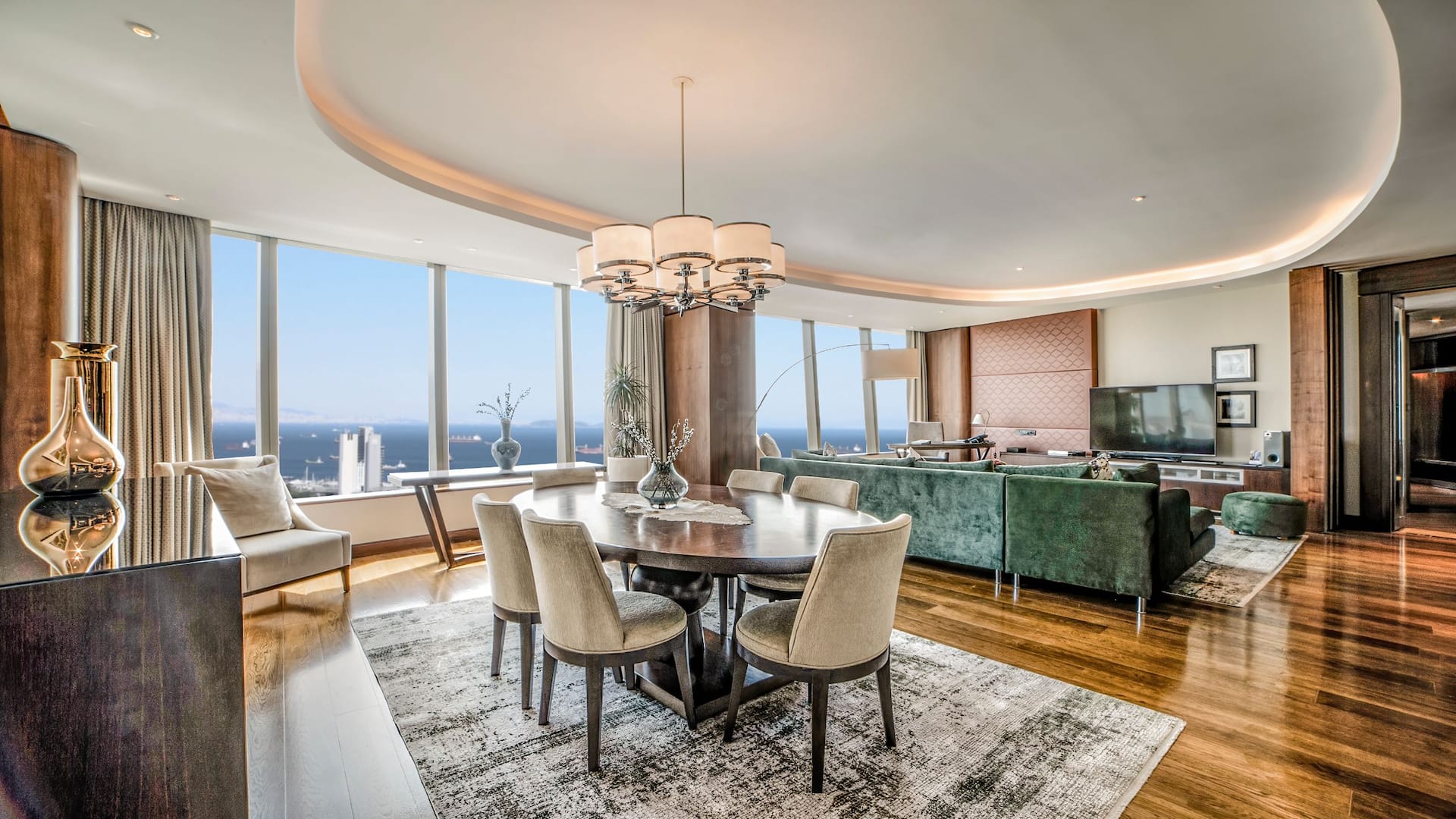 Spacious Marmara Suite at Hyatt Regency Istanbul Ataköy featuring floor-to-ceiling windows with sea views, an elegant dining area, plush seating, and modern decor in an open-concept living space.