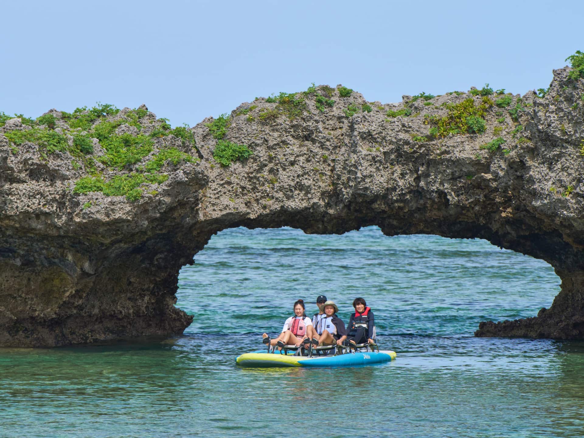 Hyatt Regency Seragaki Island, Okinawa Guests Paddle Boating Under Rock Overpass