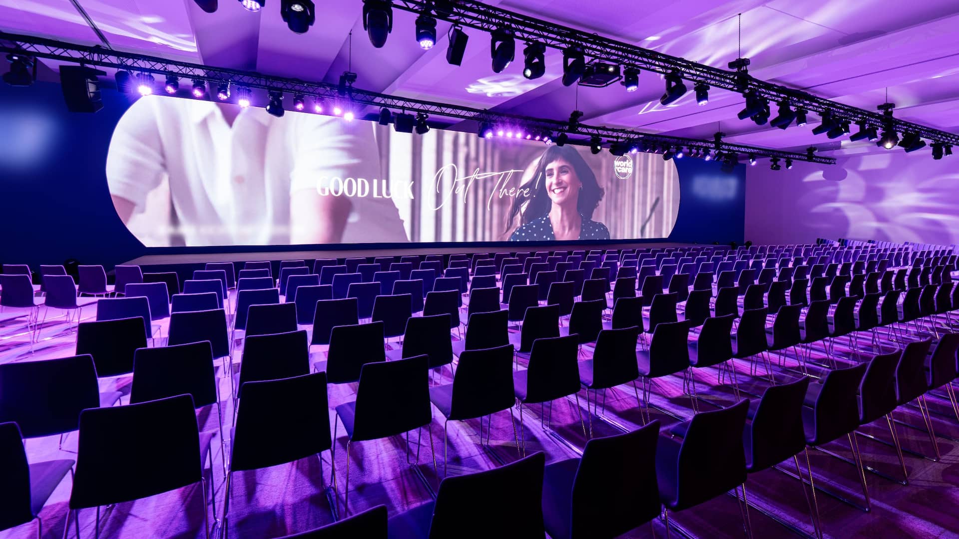 1 of 8 Sophisticated Living ABC meeting room in Barcelona at Grand Hyatt Barcelona, featuring a theater-style setup under elegant purple lighting, showcasing the premier meeting spaces in the hotel.