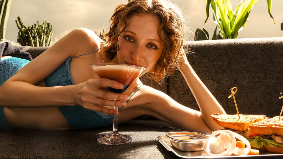 Woman holding drink in rooftop bar