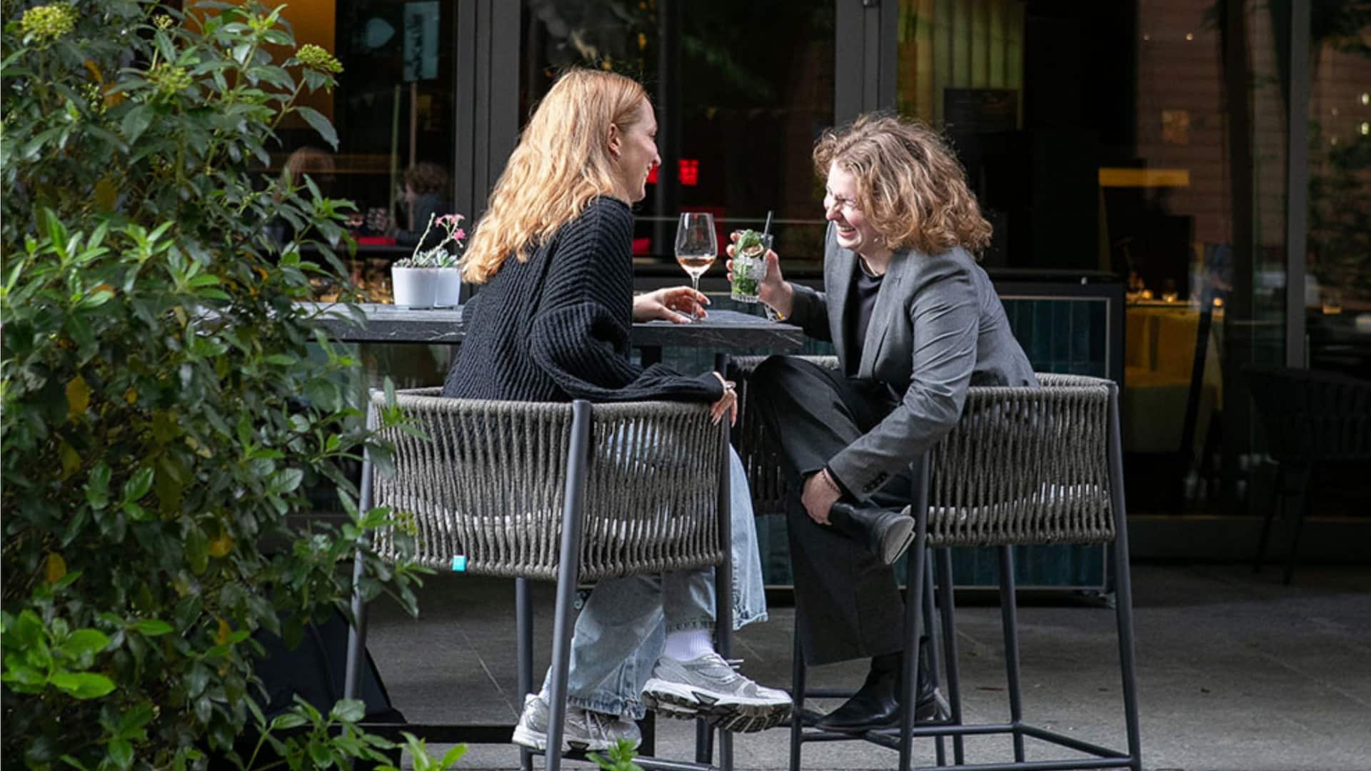 8 von 8 Grand Hyatt Berlin Guests Laughing At Terrace Bar Having Drinks