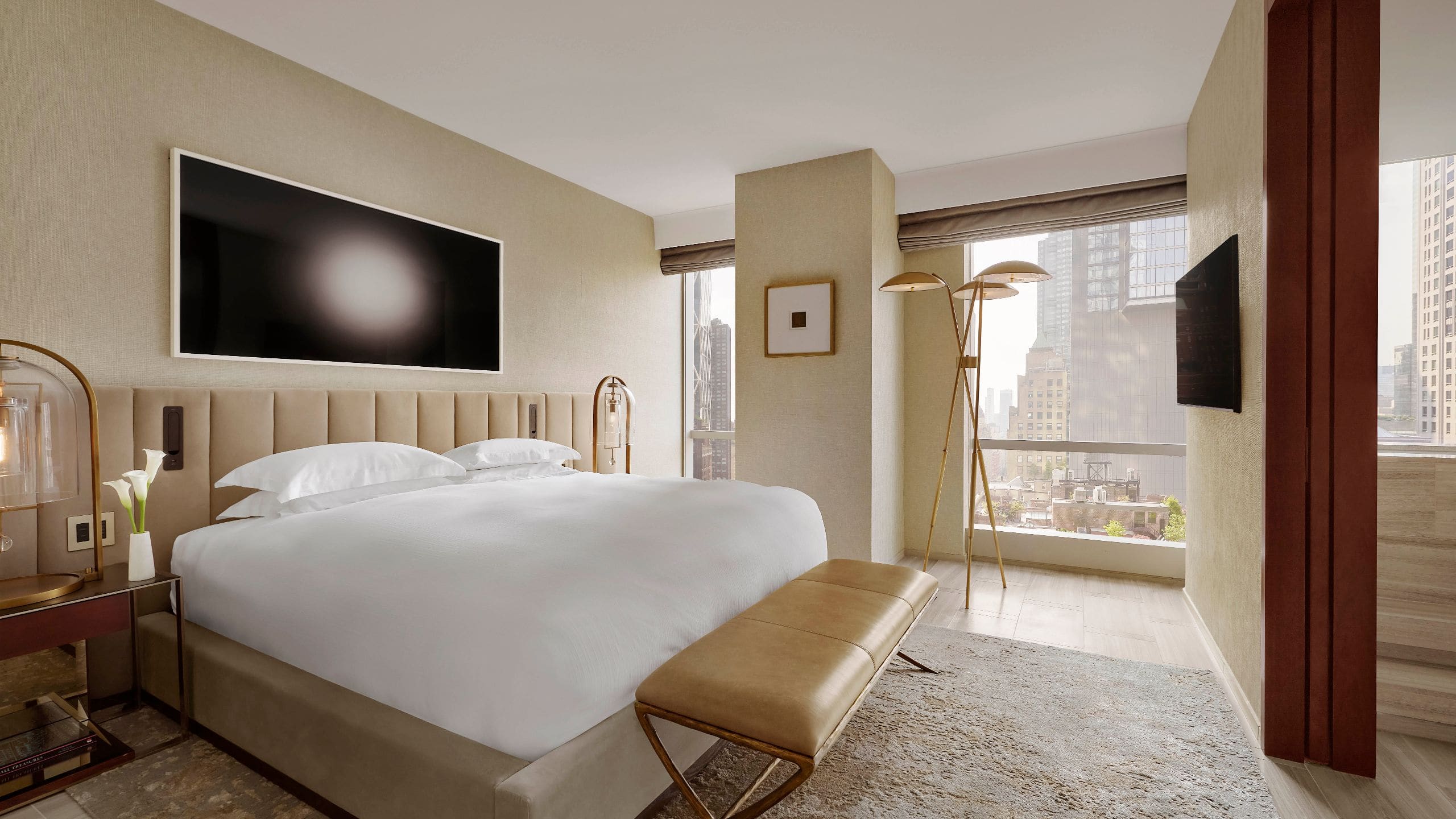 3 из 7 Contemporary suite bedroom featuring a king bed, city views, layered lighting, and warm neutral tones