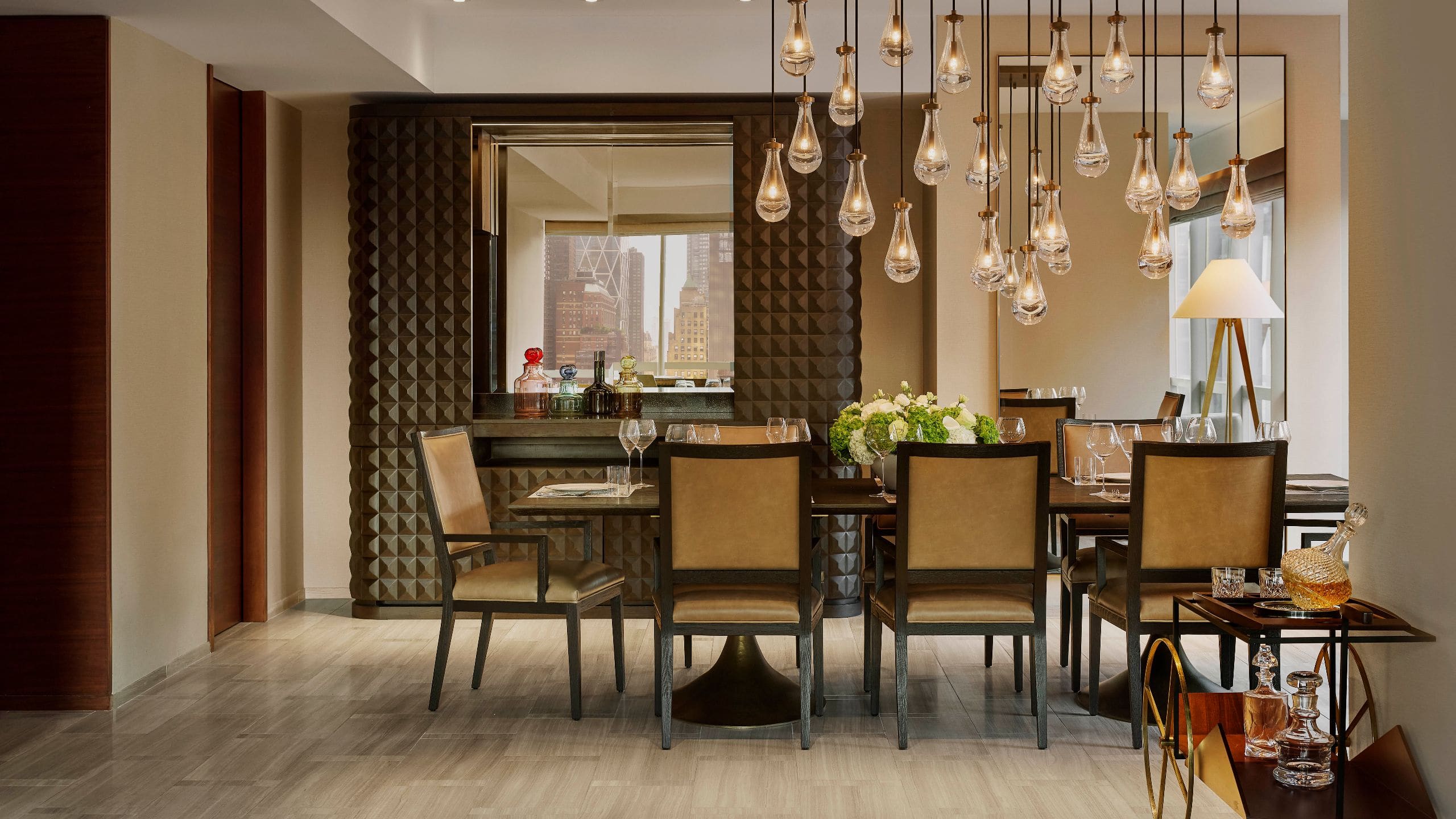 4 из 7 Refined dining room with sculptural light fixture, leather seating, and a mirrored wall reflecting the skyline