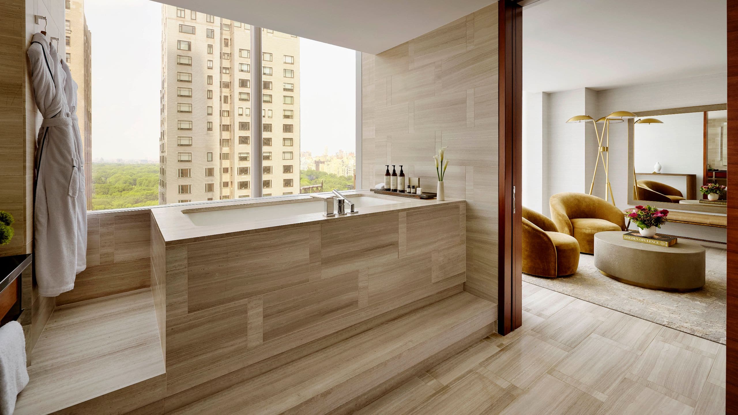 6 of 7 Sunlit bathroom with a soaking tub overlooking Central Park and a view into the elegant bedroom