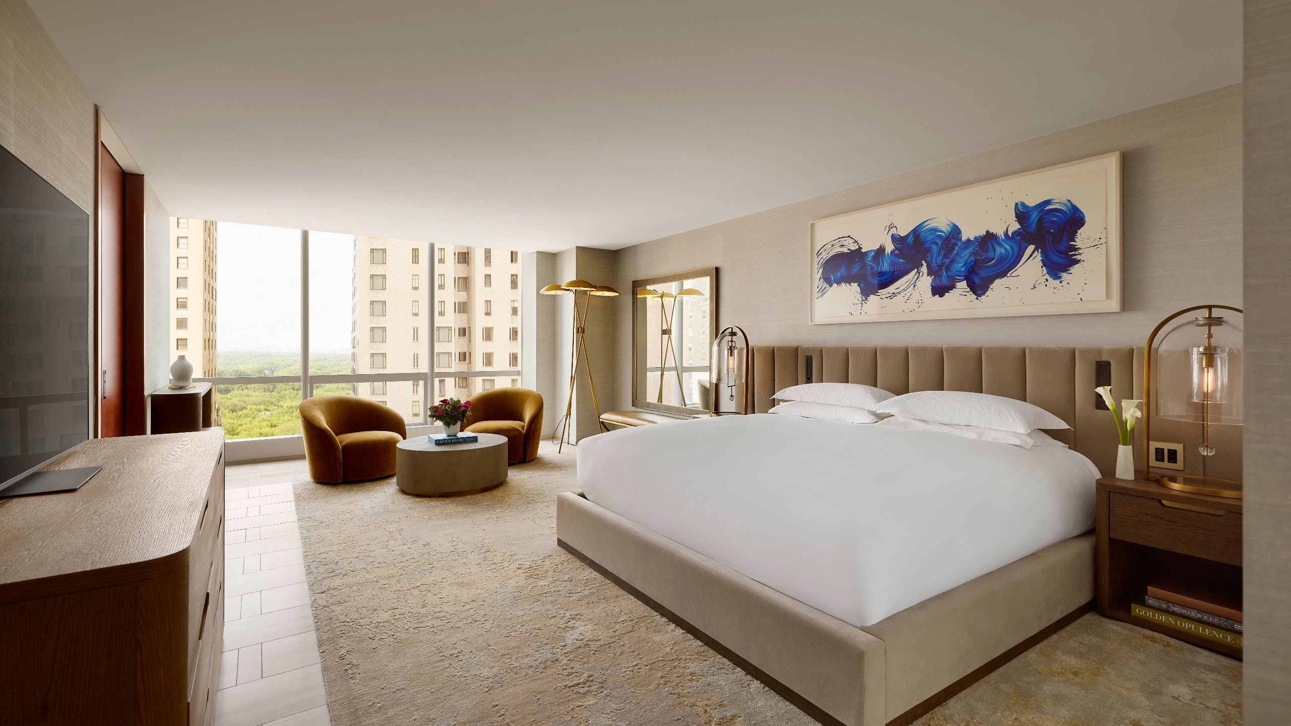 2 of 7 Expansive bedroom with king bed, velvet armchairs, and floor to ceiling views of Central Park