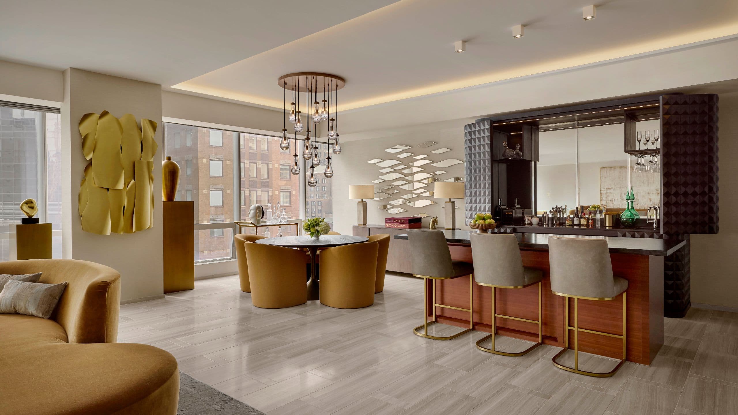 5 of 7 Sculptural chandelier above a circular dining table surrounded by curved velvet chairs and curated art