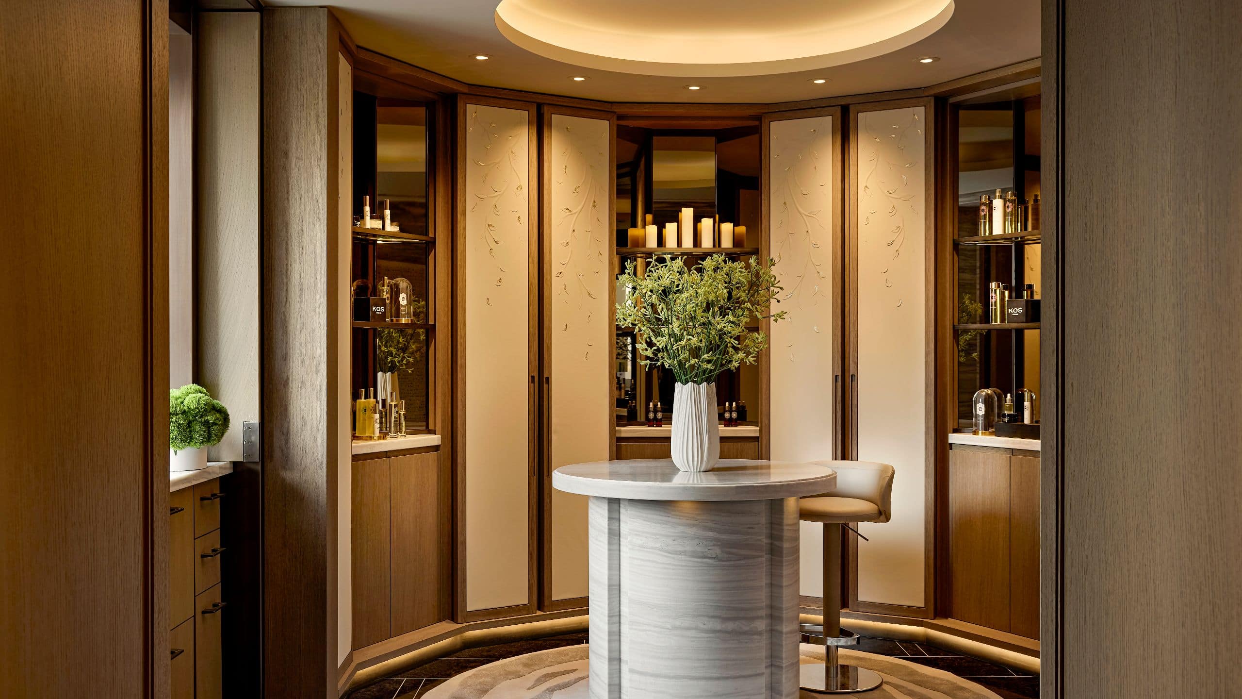 Reception area with a stone desk, curved architecture, and a warmly lit welcome into Spa Nalai