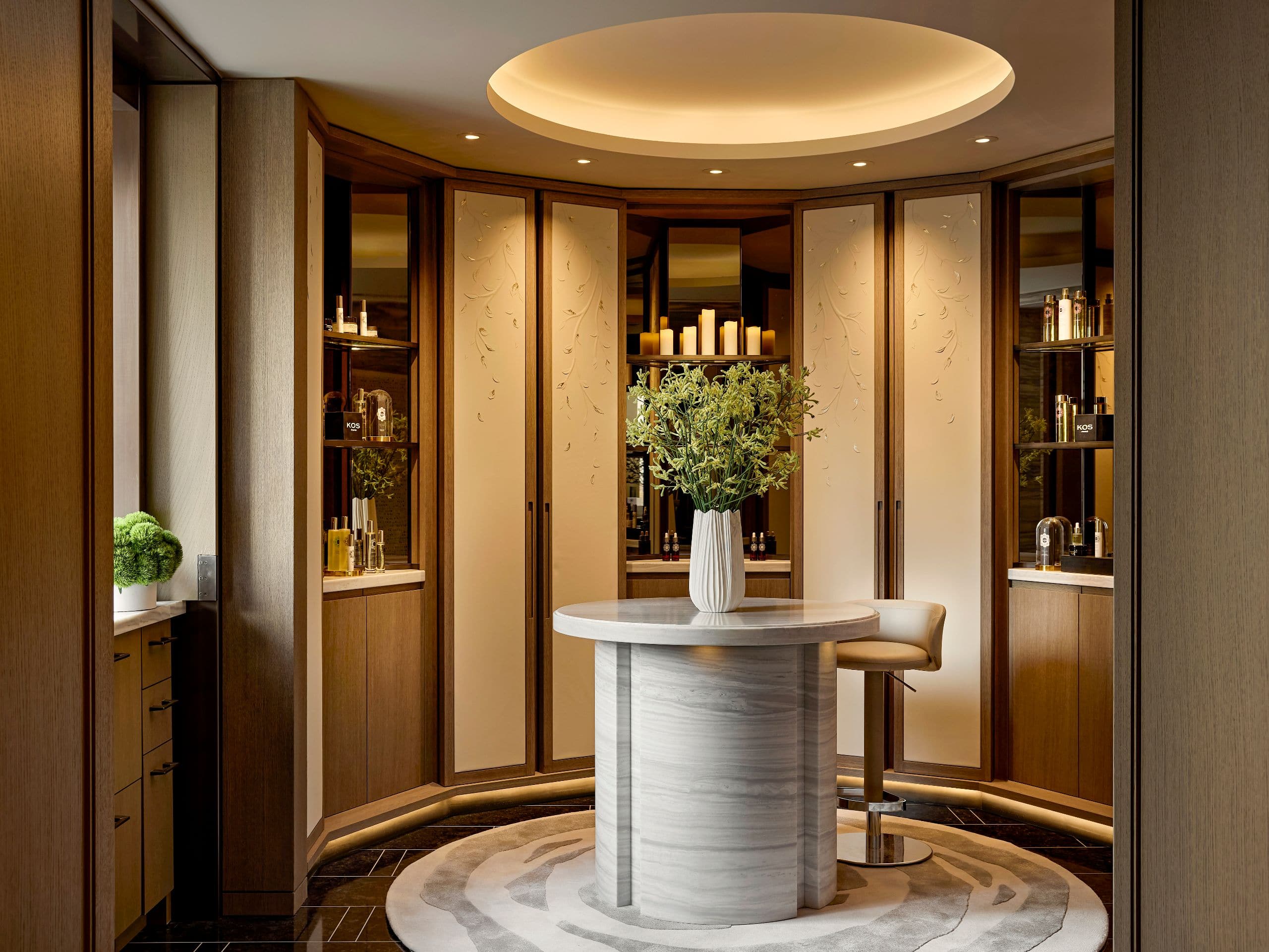 Reception area with a stone desk, curved architecture, and a warmly lit welcome into Spa Nalai