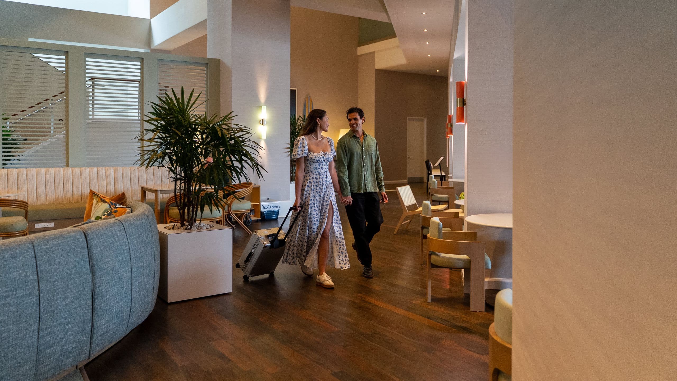 Hyatt Centric Delfina Santa Monica Couple Walking Through Lobby With Suitcase