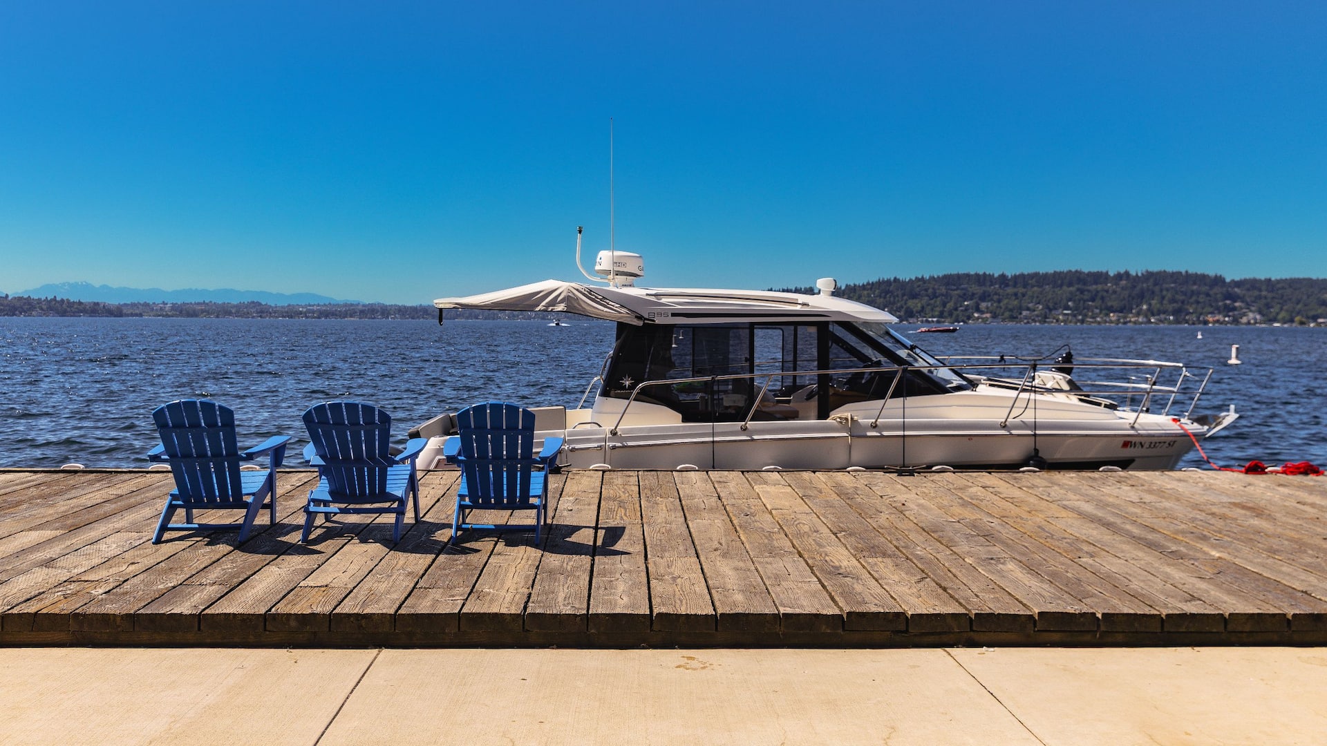Hyatt Regency Lake Washington at Seattle's Southport Dock With Boat And Blue Chairs