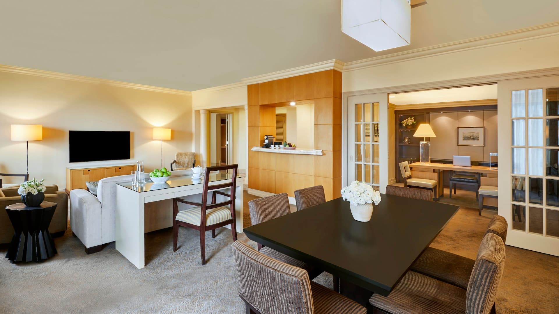 Executive Suite at the luxury Istanbul hotel, Grand Hyatt Istanbul, featuring a cozy cream-toned living room with dim lighting, plush seating, and a dining area in the background.